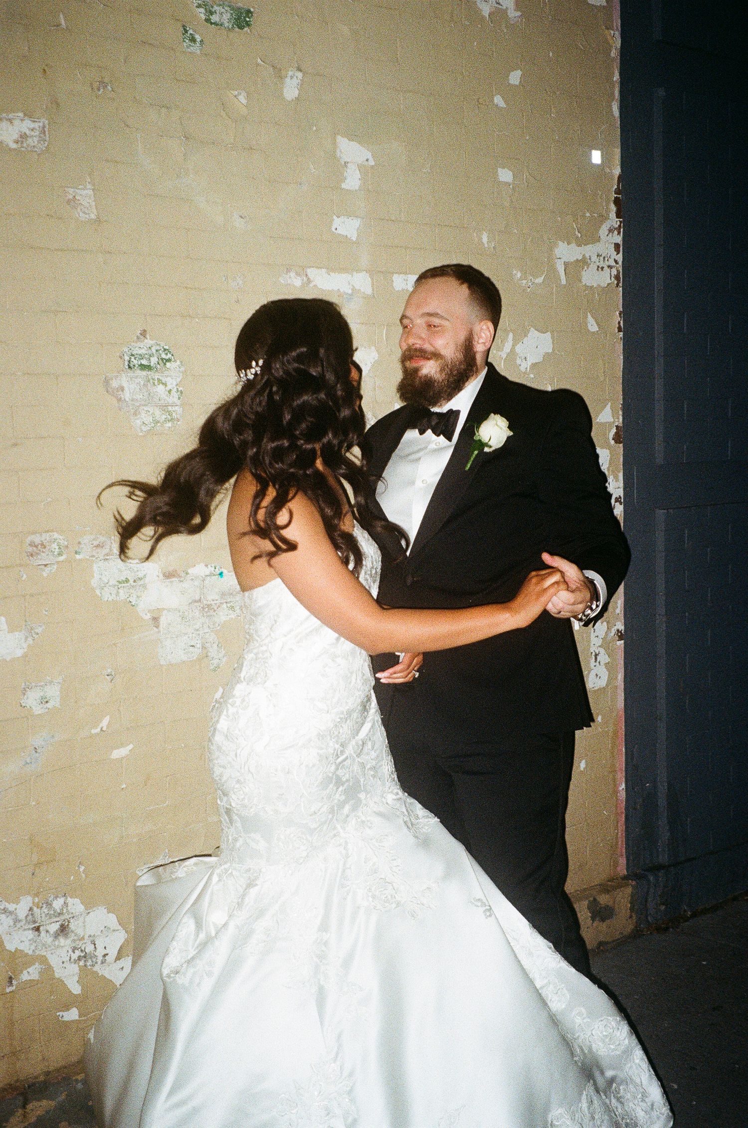 A couple performs an energetic dance move during their wedding celebration.