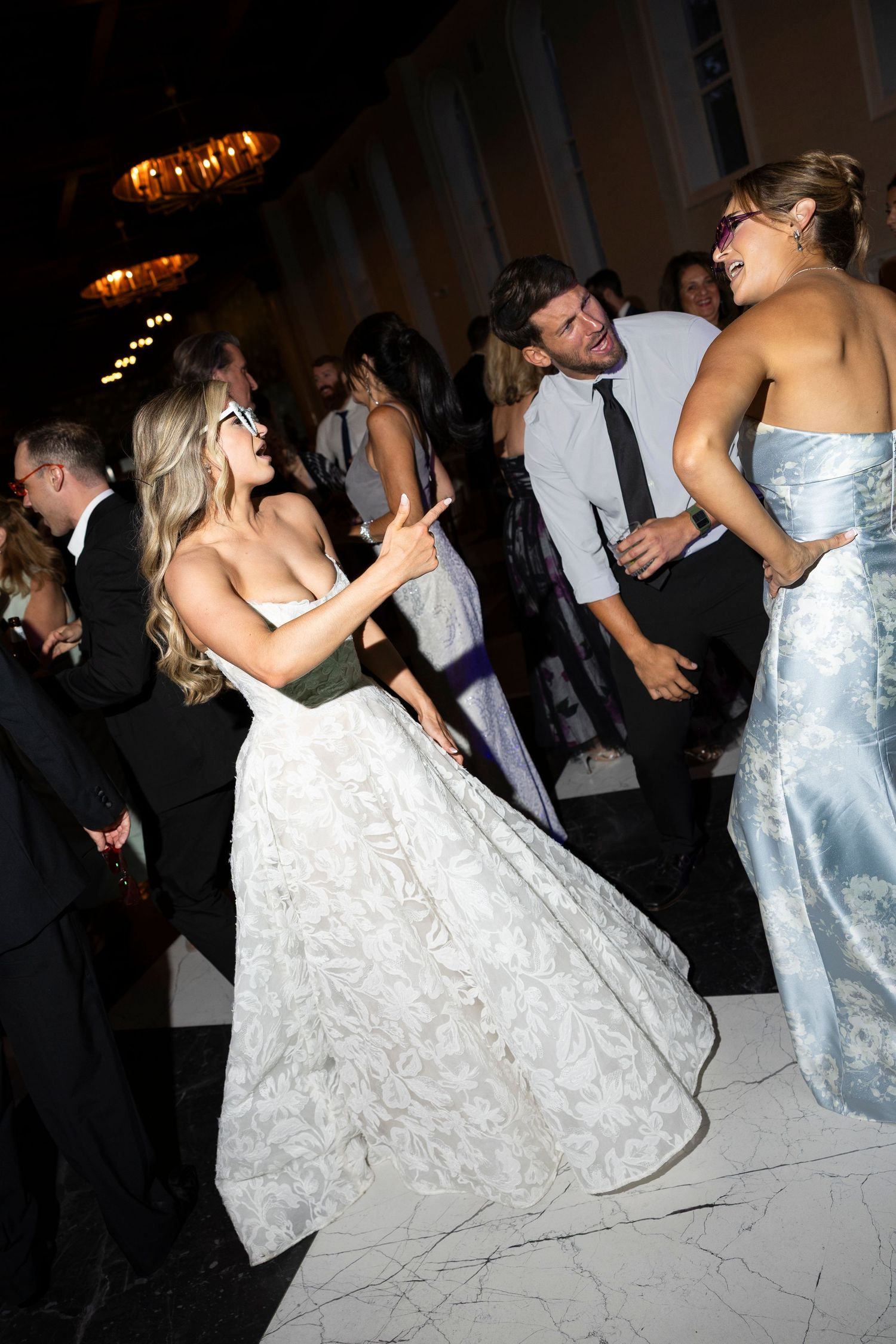 Wedding reception dance floor with couples in formal attire.