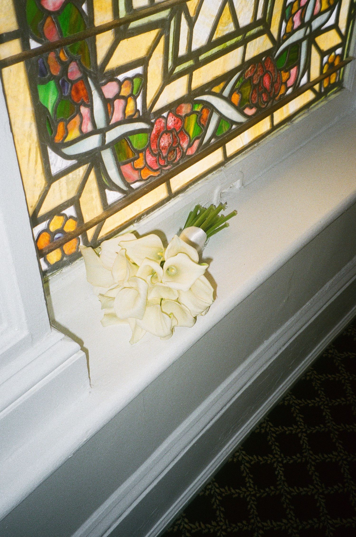 Decorative stained glass window panels with colorful floral and fruit designs.