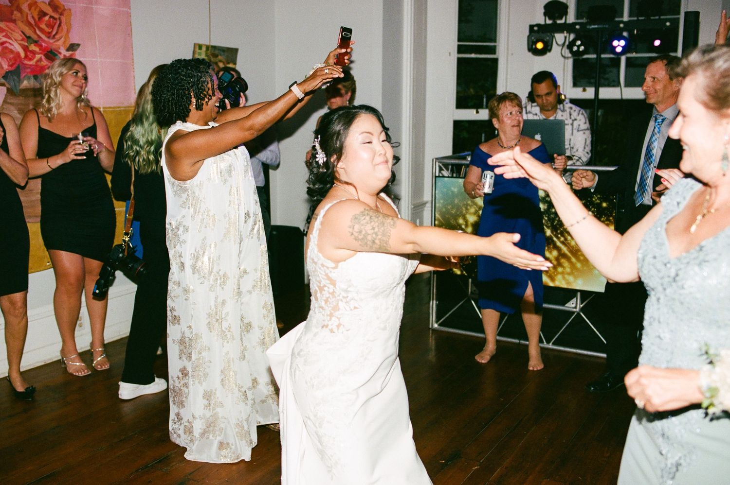 Wedding reception dance floor filled with guests celebrating and dancing together.