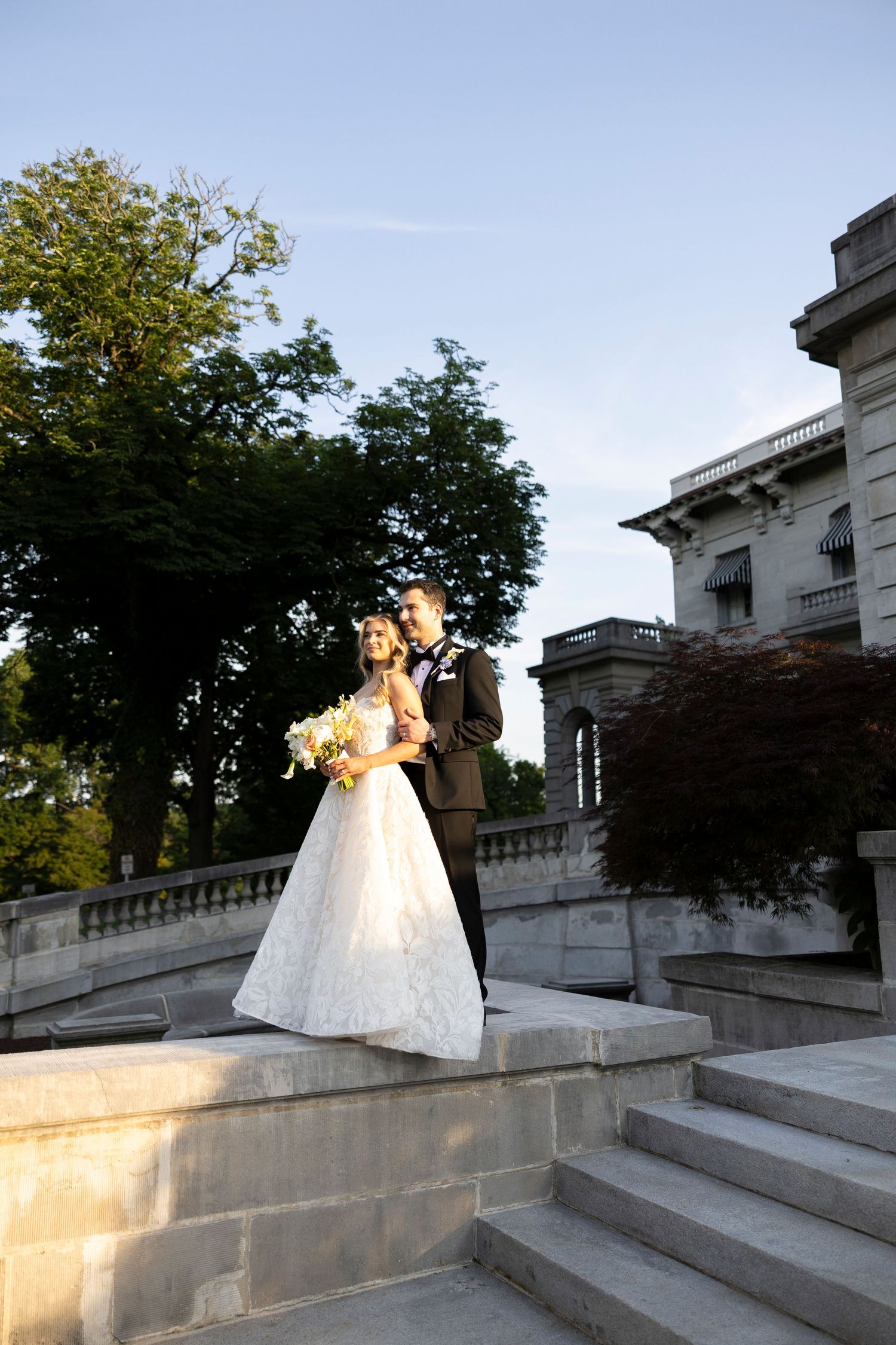 Golden hour wedding photography on grand stone steps with dramatic lighting and shadows.