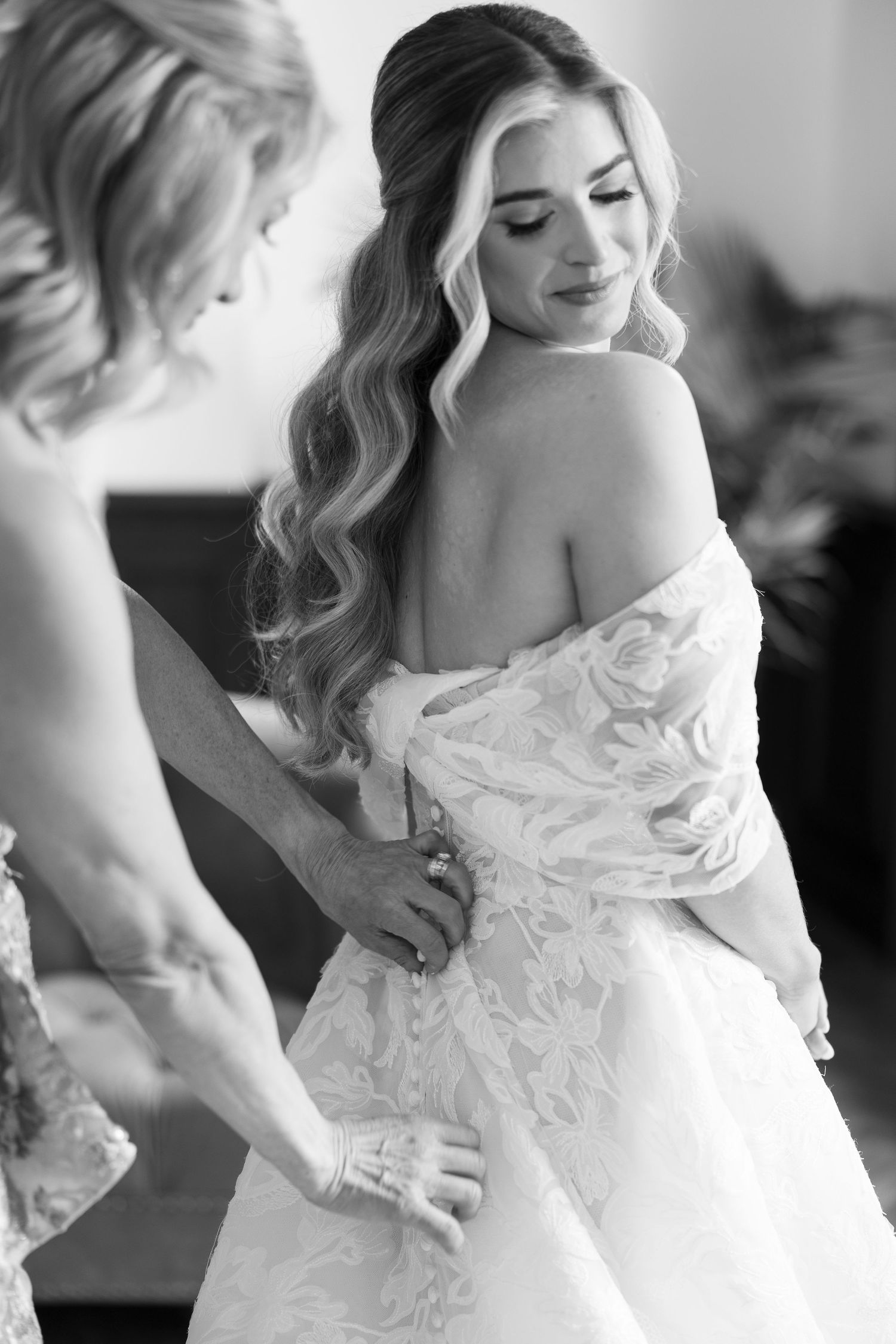 Artistic black and white portrait of a bride in an off-shoulder lace wedding gown.