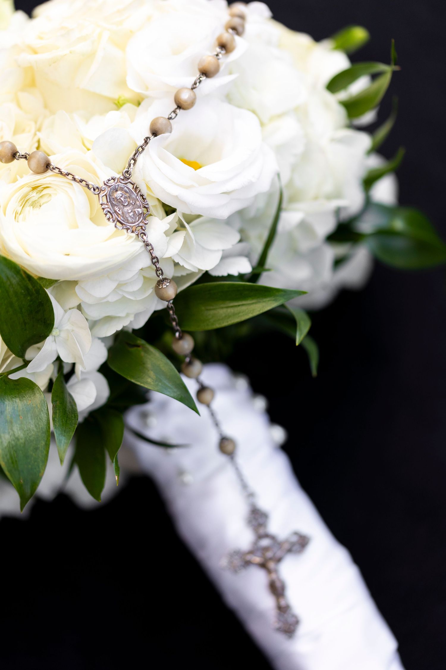 White rose wedding bouquet wrapped in ribbon with pearl accents.