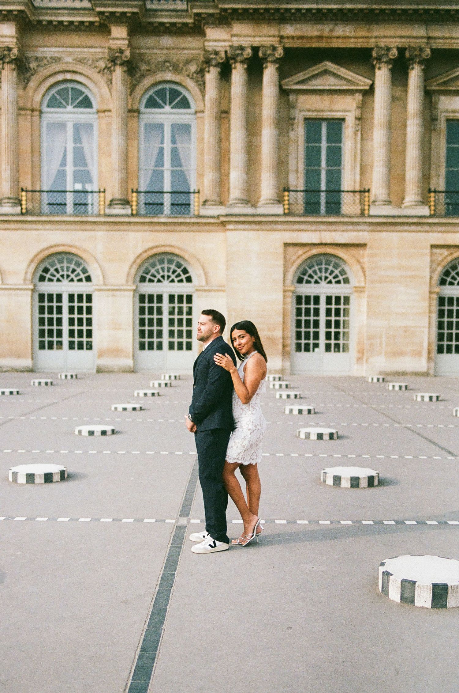 Architectural engagement photos at Palais Royal with classic French columns and striped pillars.