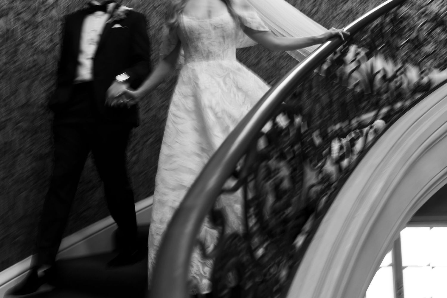 Black and white artistic photo of couple on grand staircase.