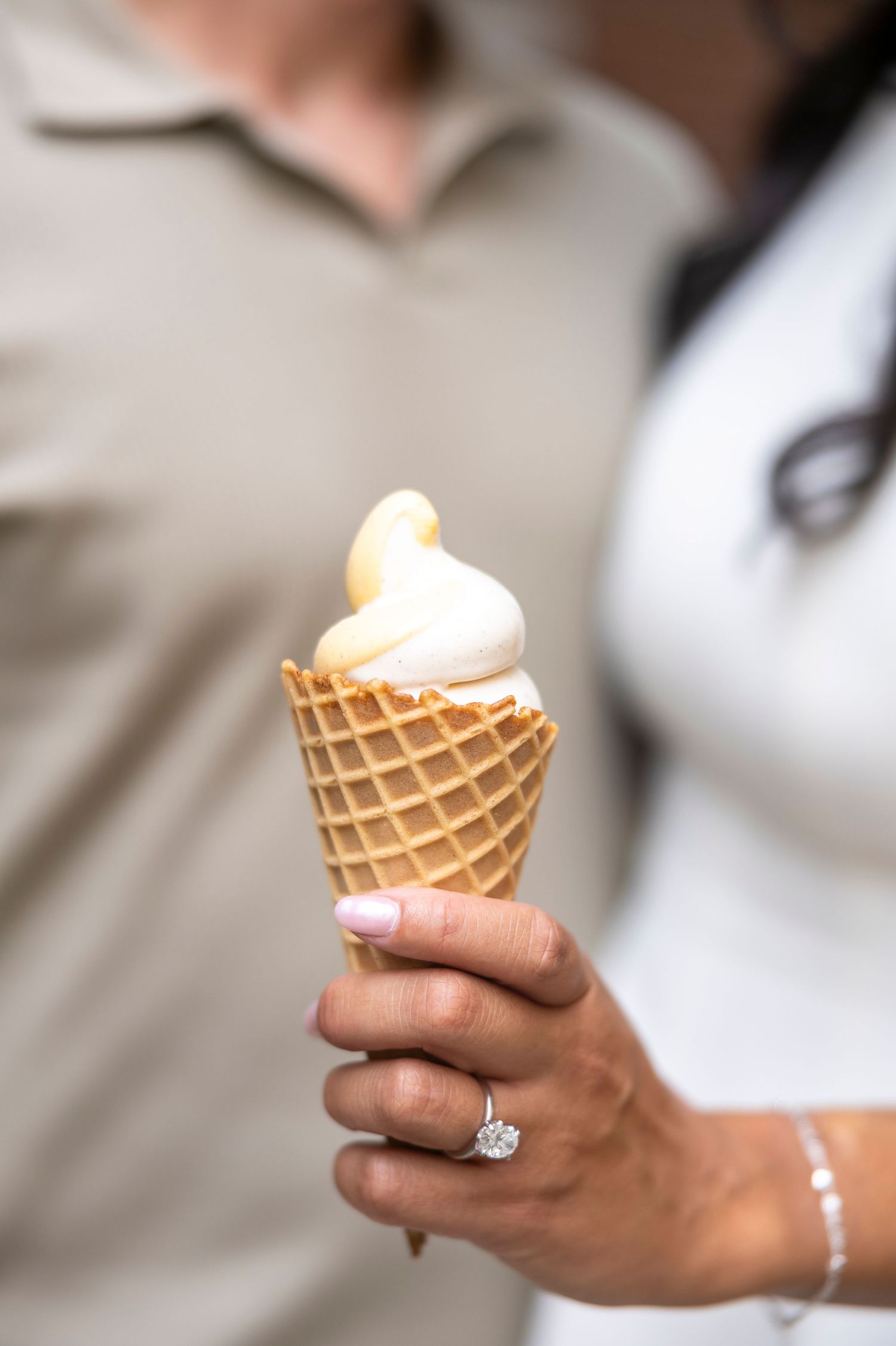 Close-up shots of hands holding a vanilla ice cream cone with an engagement ring visible.