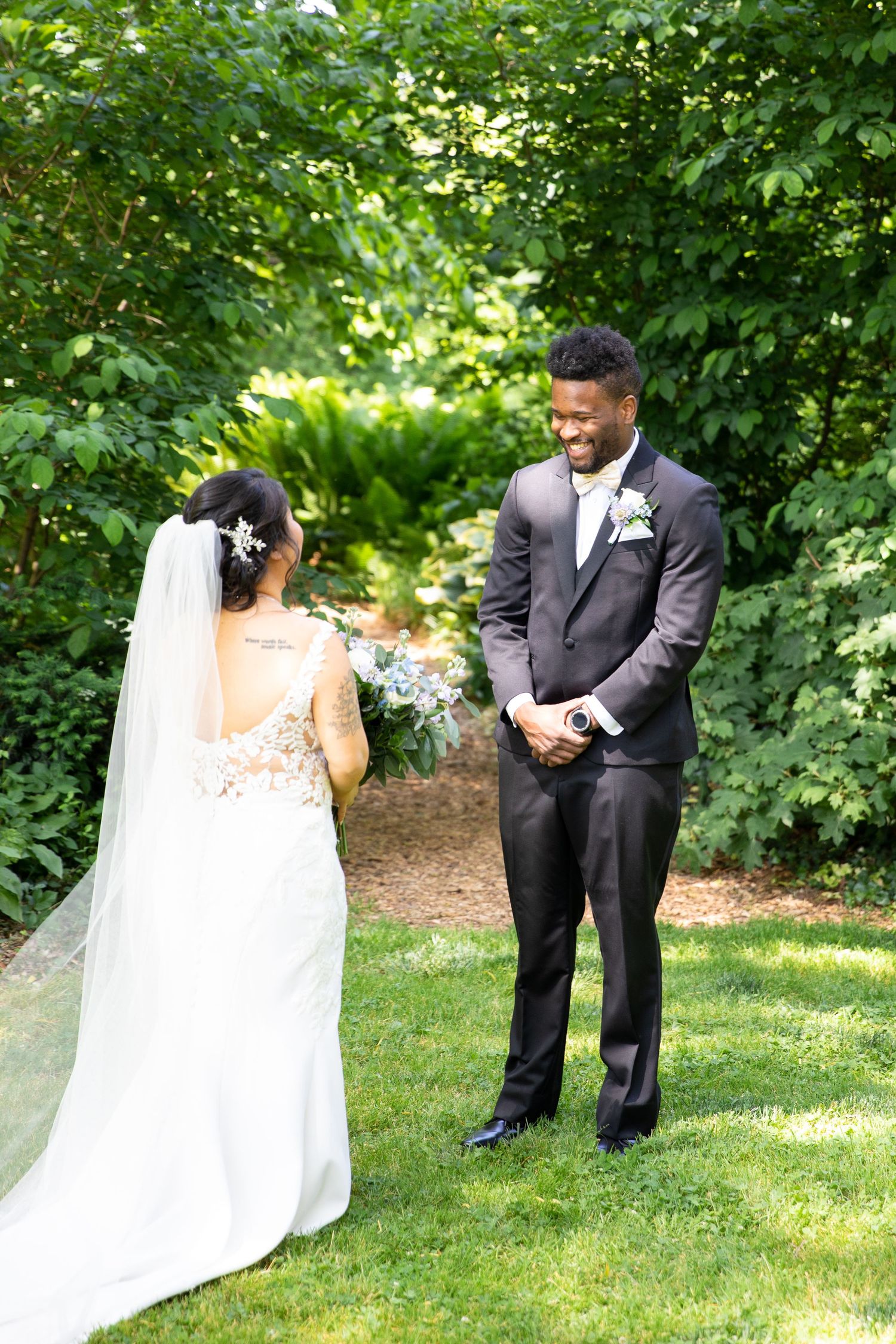 A couple shares their first look moment in a garden setting during their wedding day.