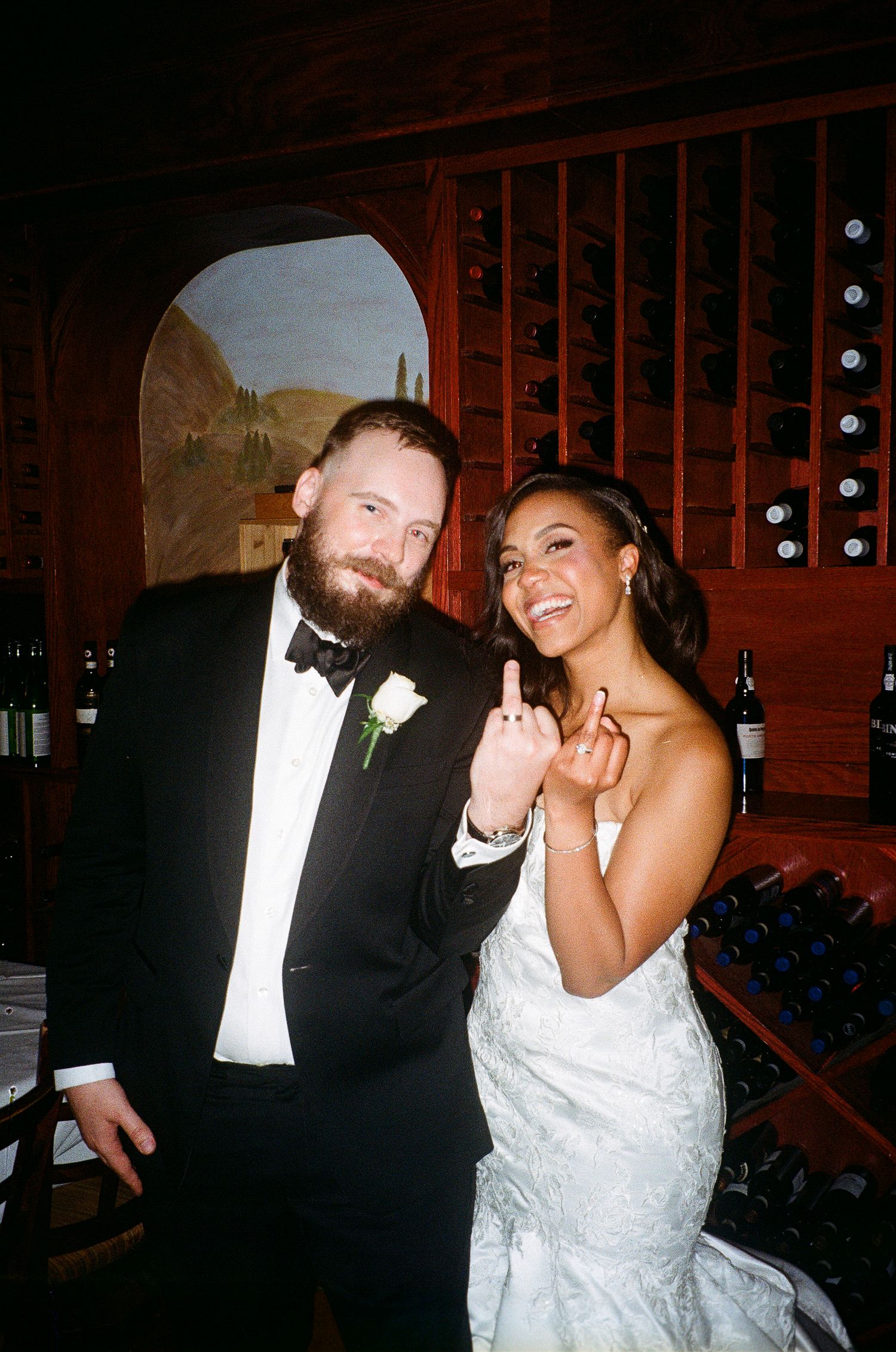 Joyful celebration moment in front of rustic wine cellar storage.