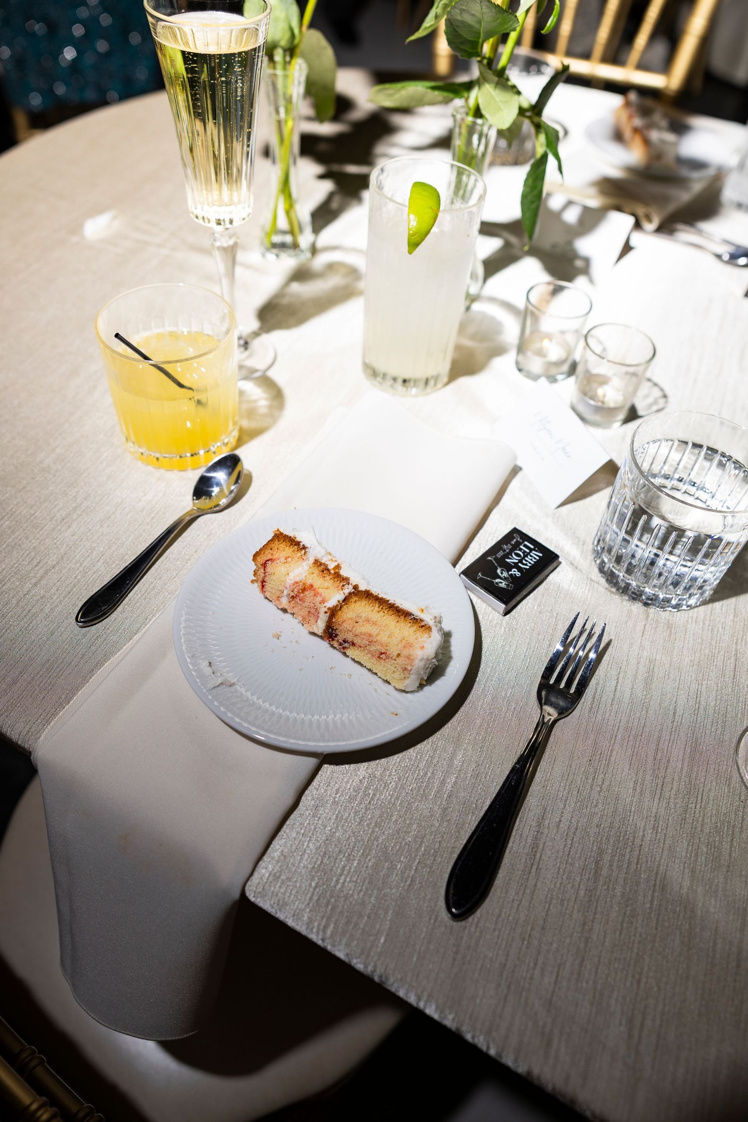 Elegant table setting with glassware, plates and floral centerpieces at a wedding reception.