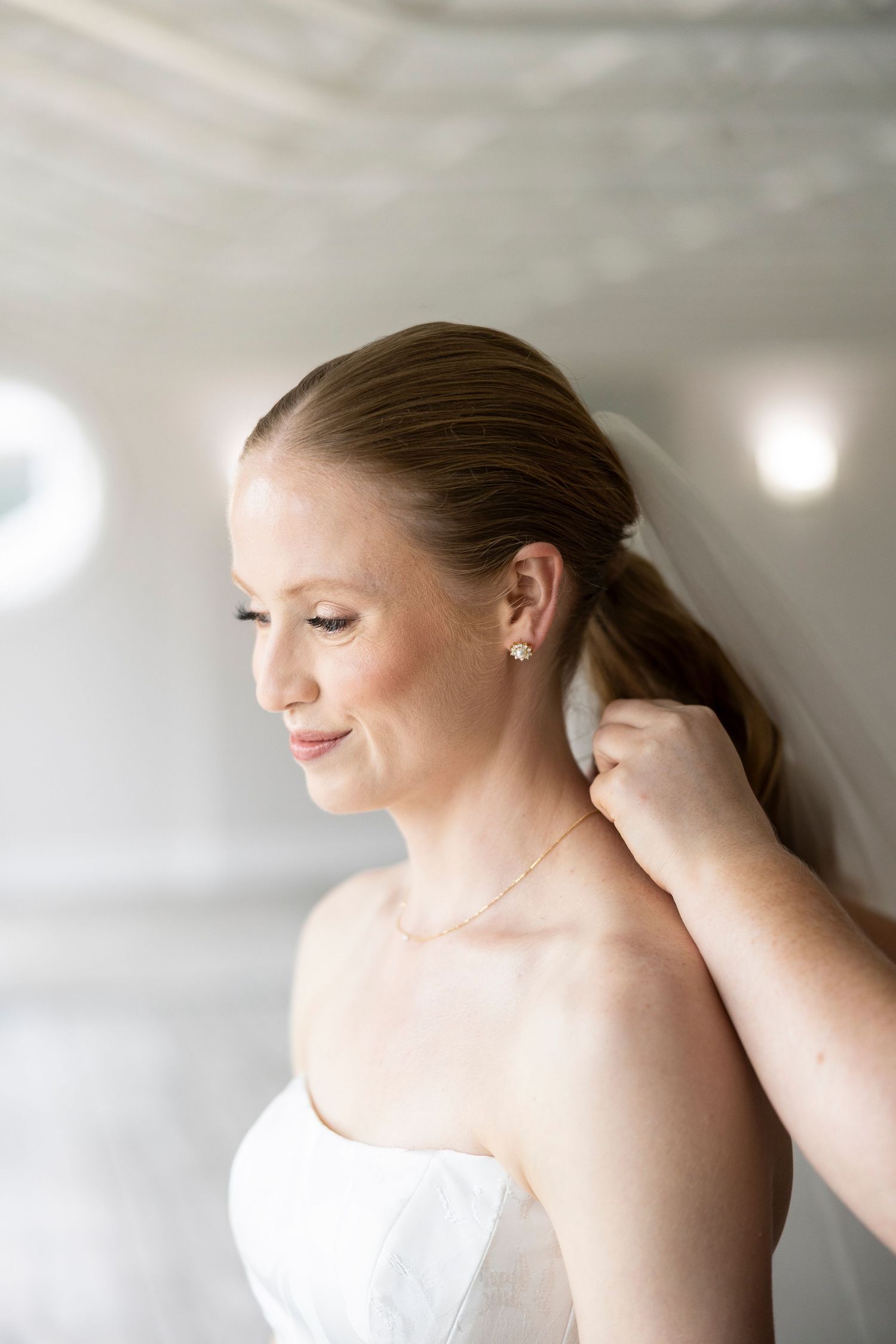 Close up of bridal beauty preparation with soft lighting and delicate veil.