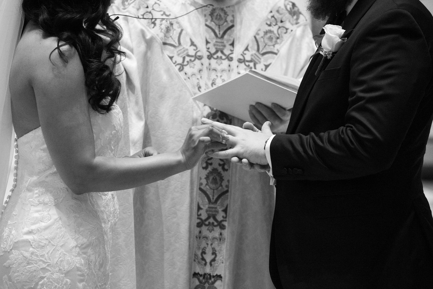 Bride and groom hold hands during their wedding ceremony in a traditional church setting.