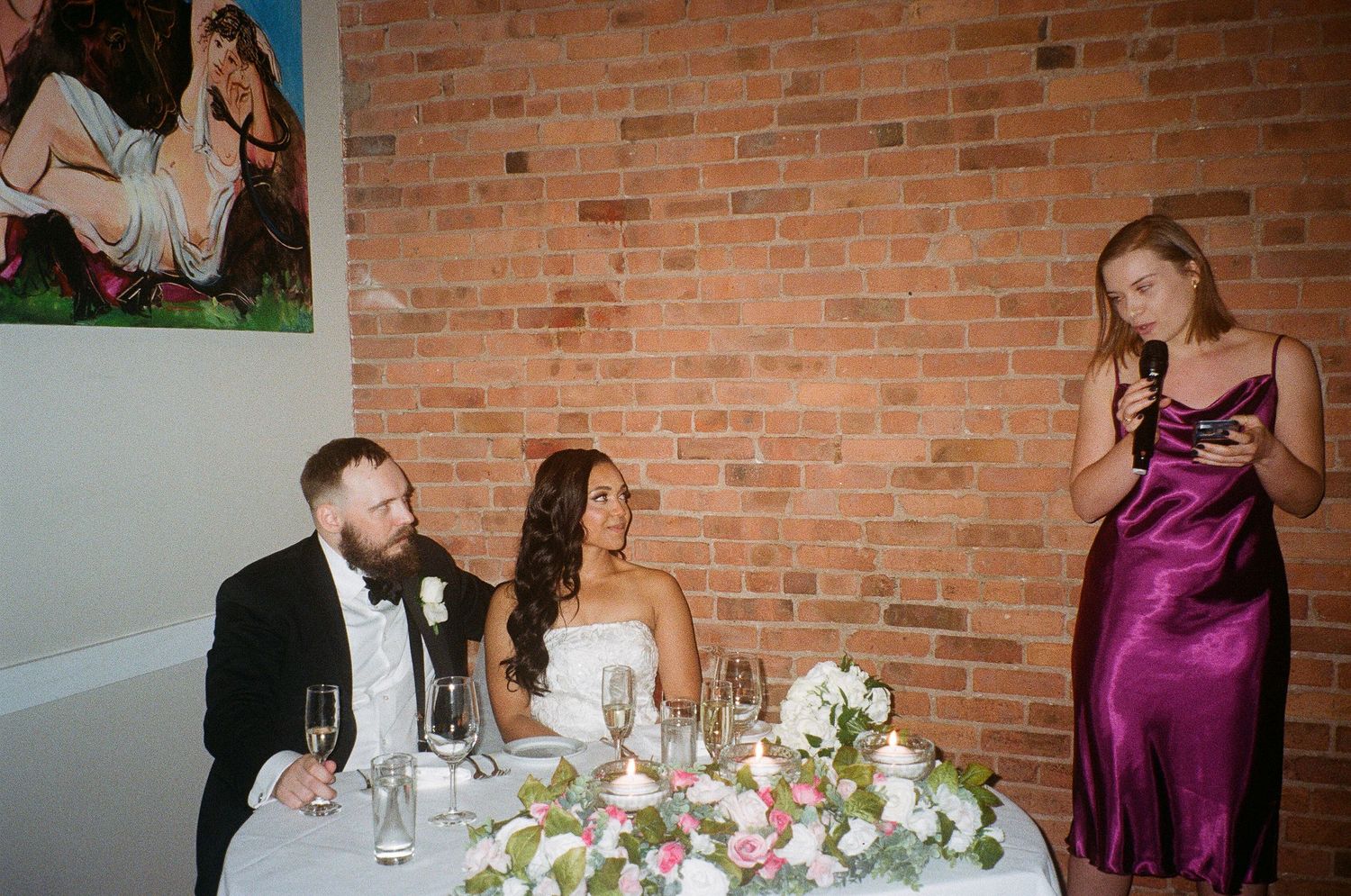 Elegant wedding reception venue with exposed brick walls and formal table settings.