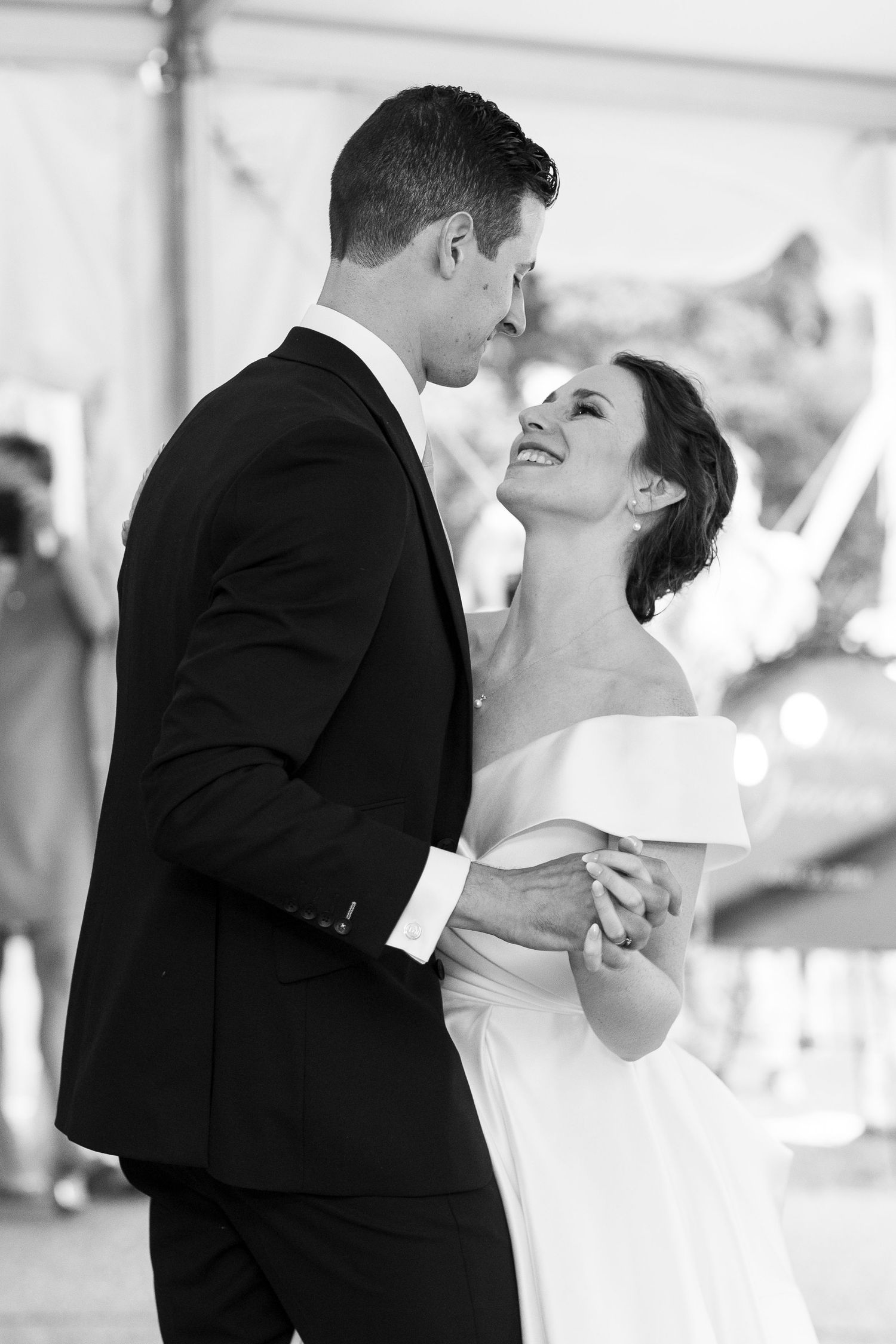A tender dance moment captured in black and white at an elegant wedding celebration.