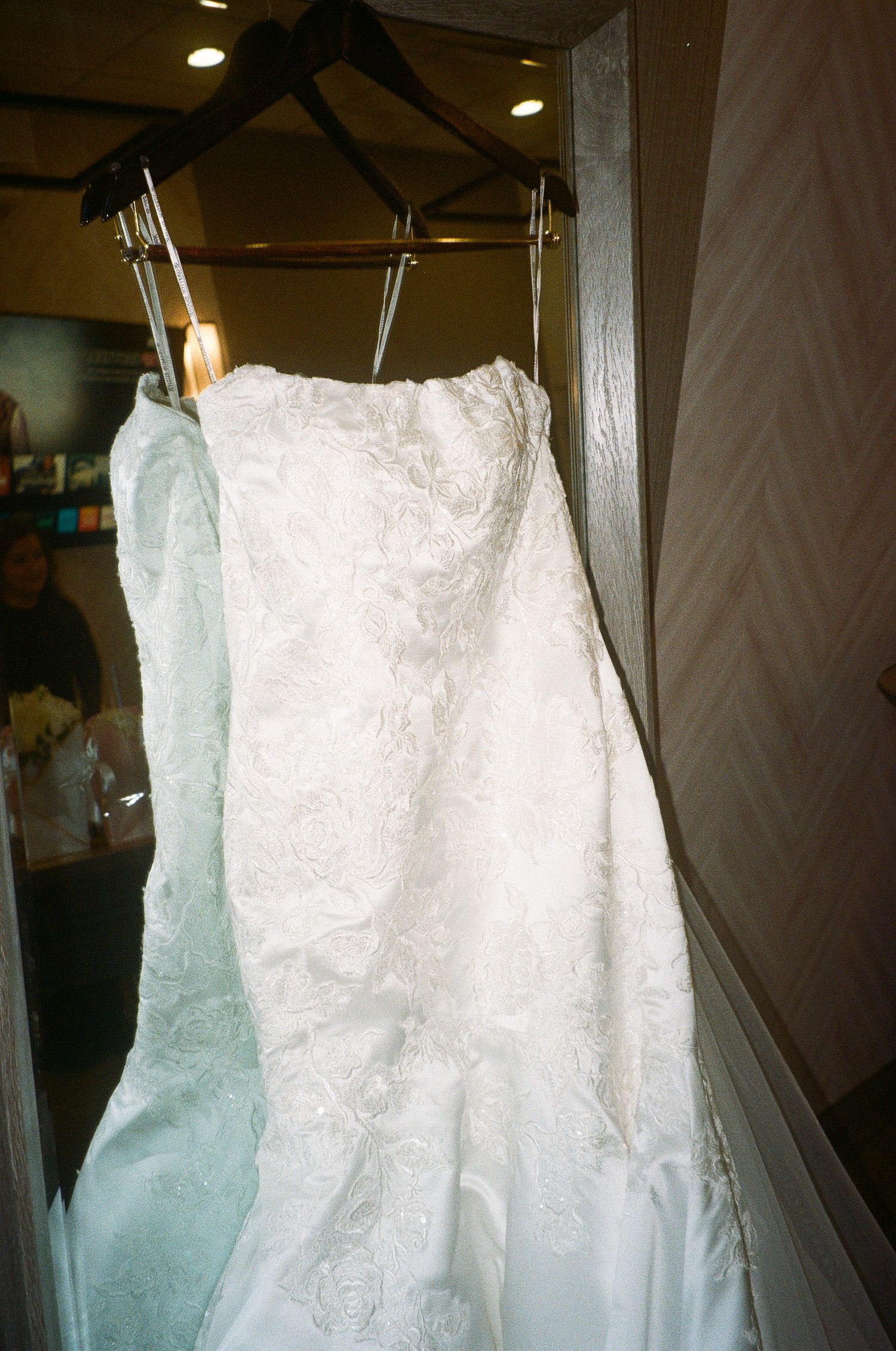 Series of hanging white wedding dresses photographed in soft lighting conditions.