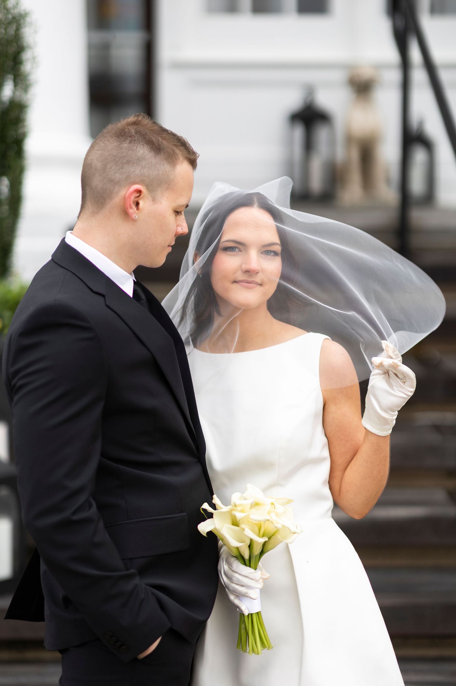 A couple shares an intimate moment outdoors with the bride holding a yellow bouquet.