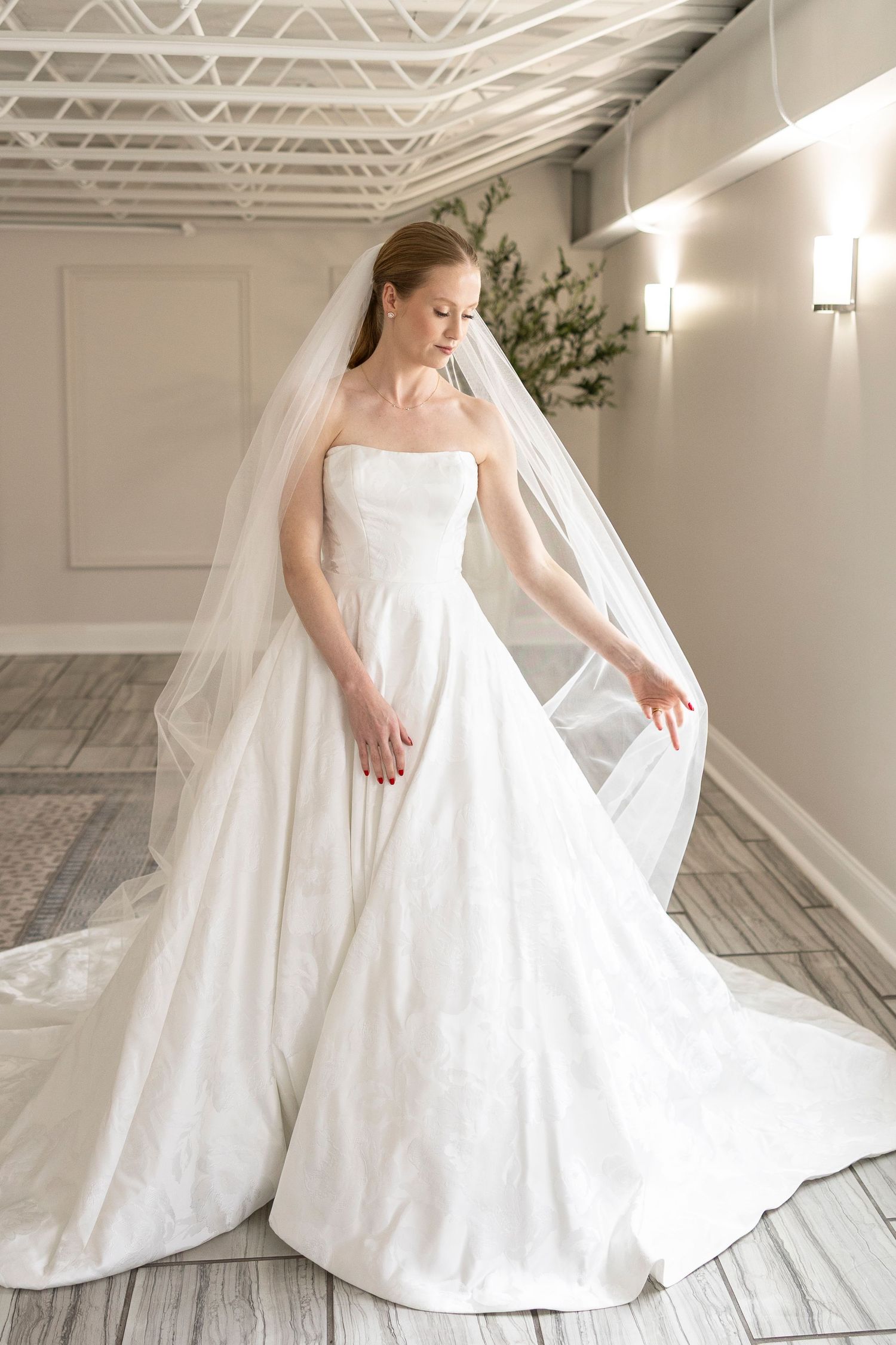 Elegant bridal portrait showing movement of full skirt against modern studio backdrop.