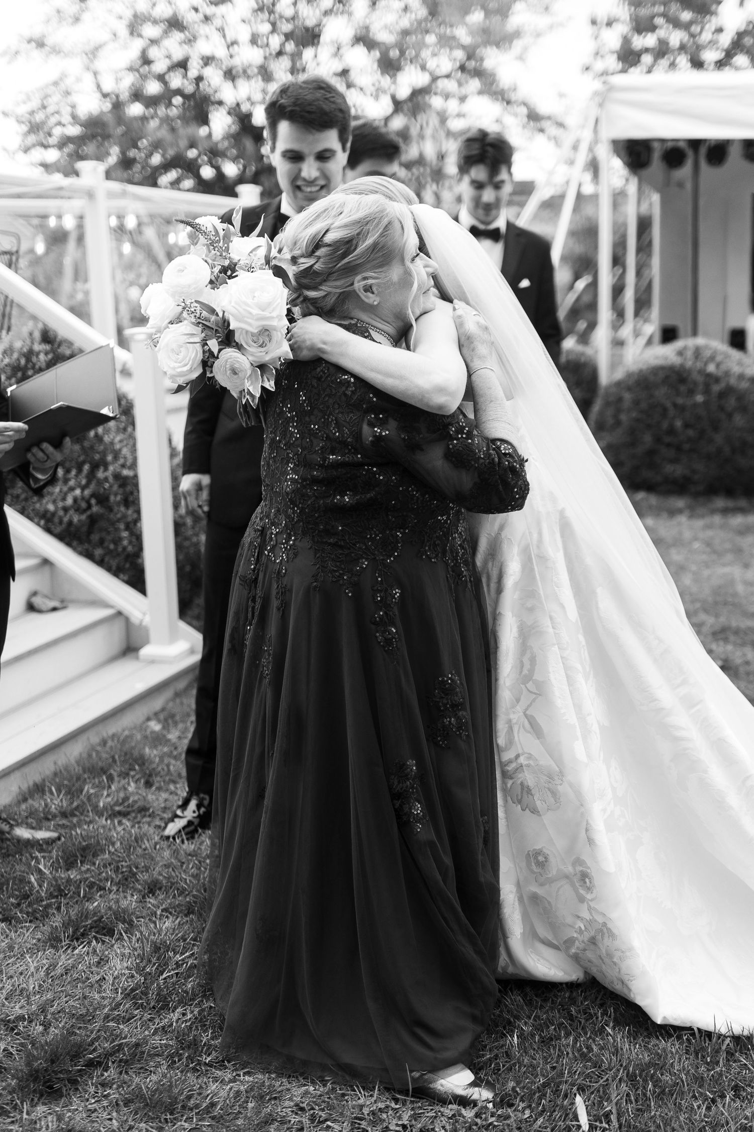 An emotional black and white moment captured during wedding congratulations on outdoor steps.