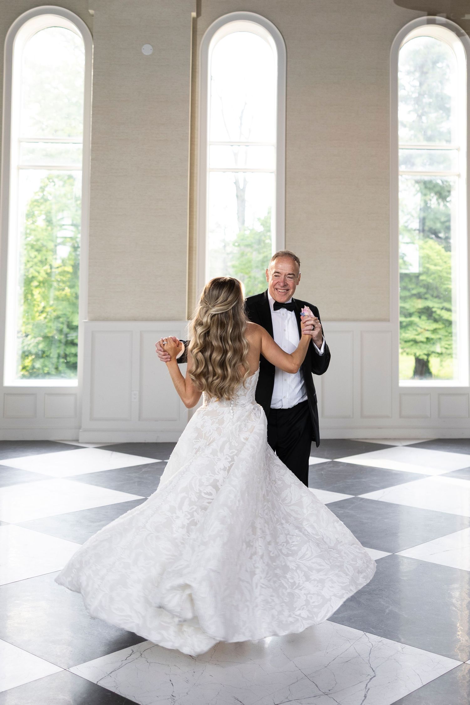 A romantic dance sequence in a bright ballroom with black and white checkered flooring.