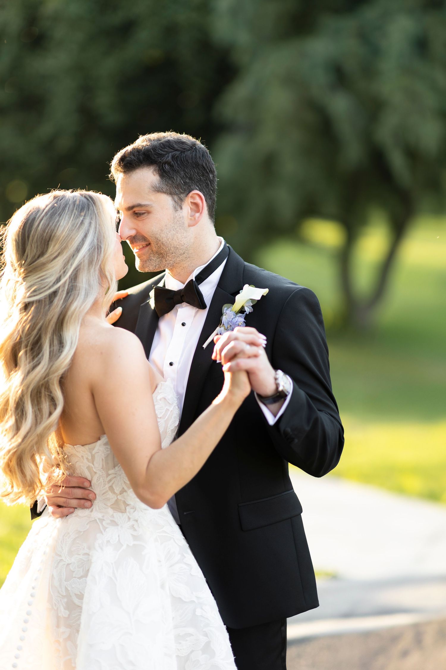 Romantic wedding couple shares intimate moments in a sunlit garden setting.