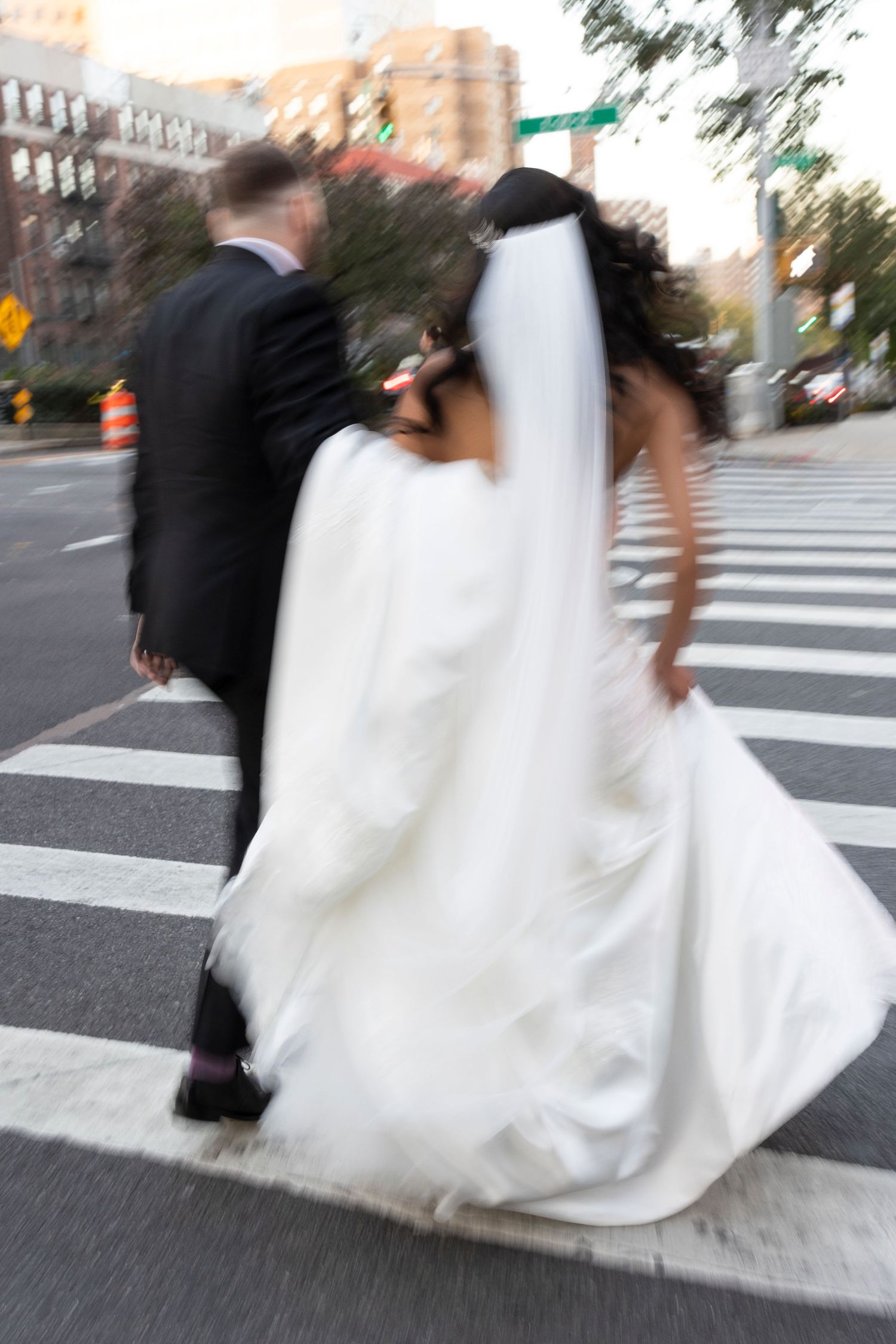 Artistic motion blur capture of wedding attire against city street backdrop.