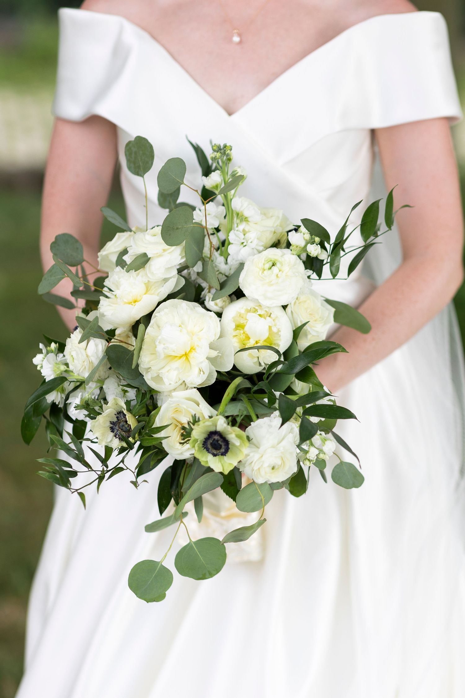 White and cream wedding bouquets with eucalyptus leaves and anemone flowers.