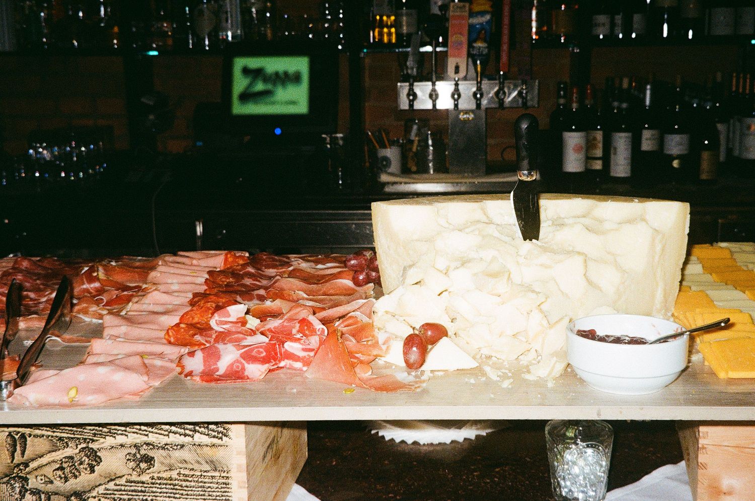 Catering display with food and serving platters at a dimly lit event.