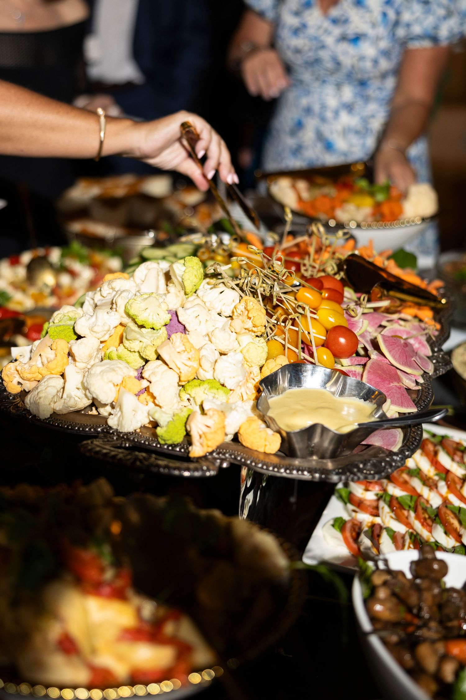 Colorful appetizers and hors d'oeuvres displayed on catering platters at an event.