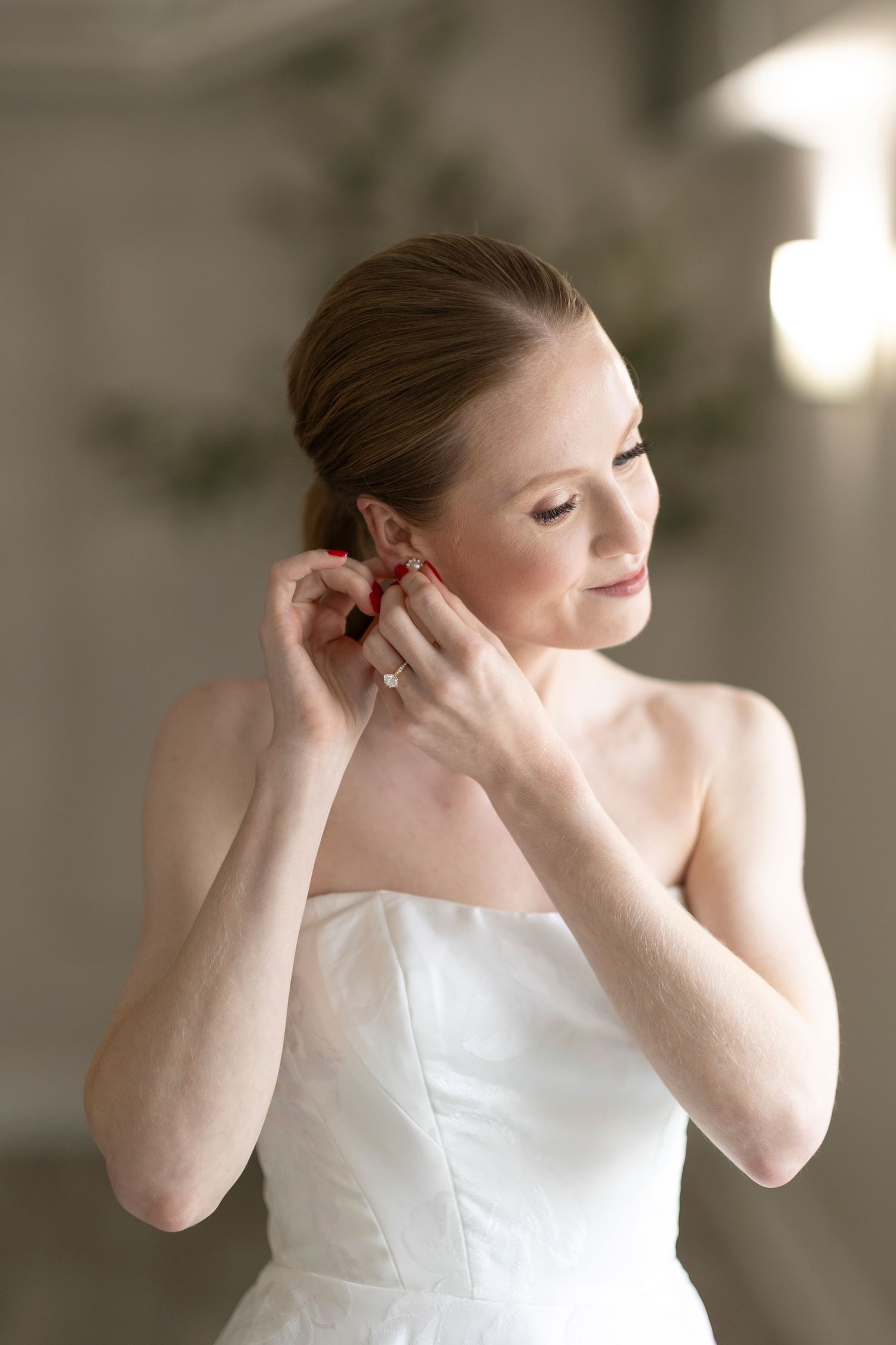 Series of photos showing someone putting on earrings while wearing a white dress.