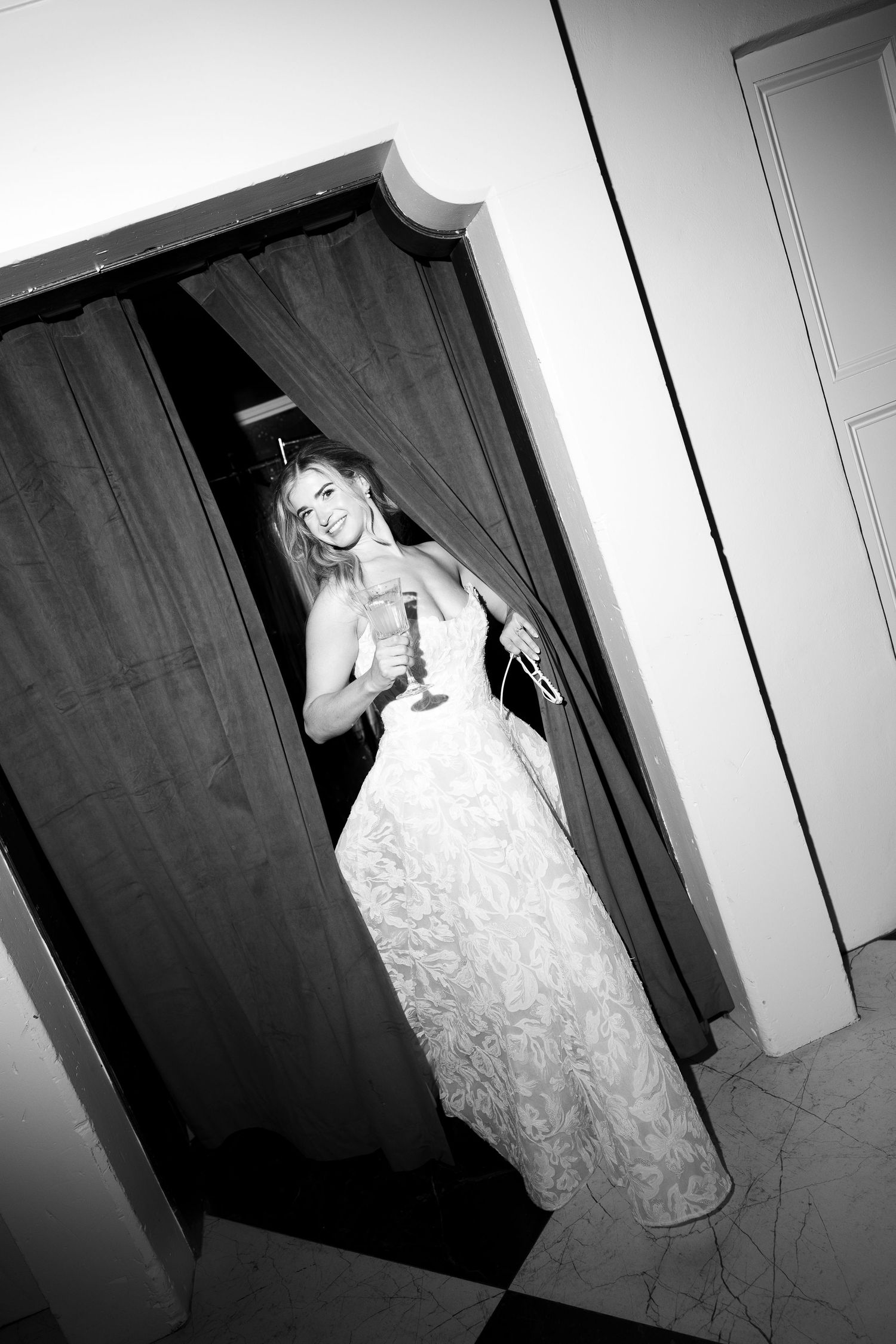 Black and white photos of a bride in a flowing white dress posing in a doorway.