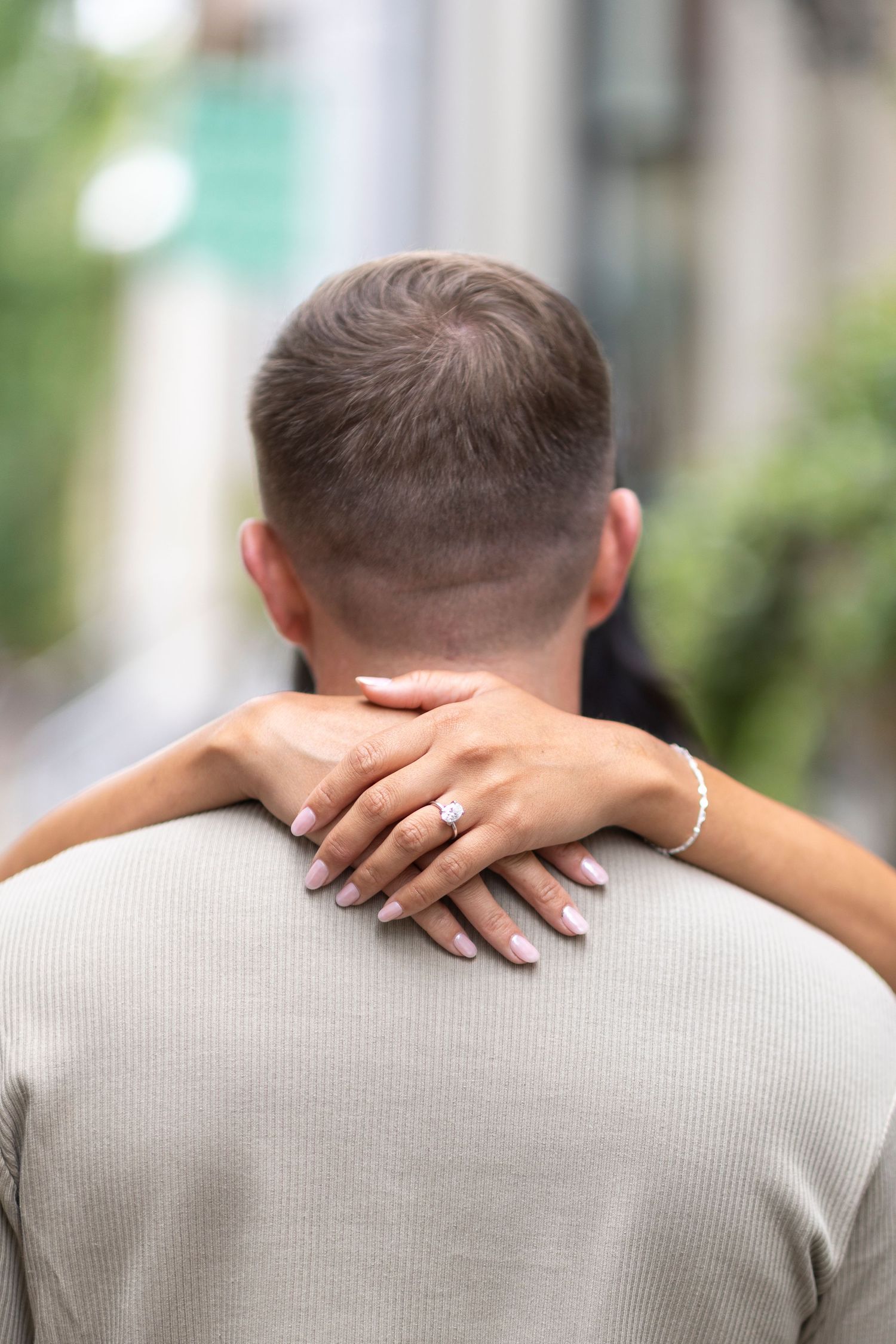 Close-up of hands resting on shoulders showing intimacy and connection in an engagement photo session.