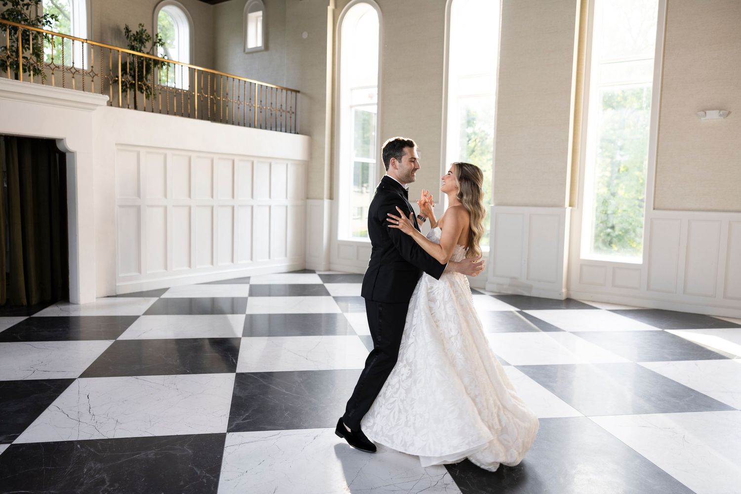 Dancing sequence in a sunlit ballroom with dramatic shadows and checkered flooring.