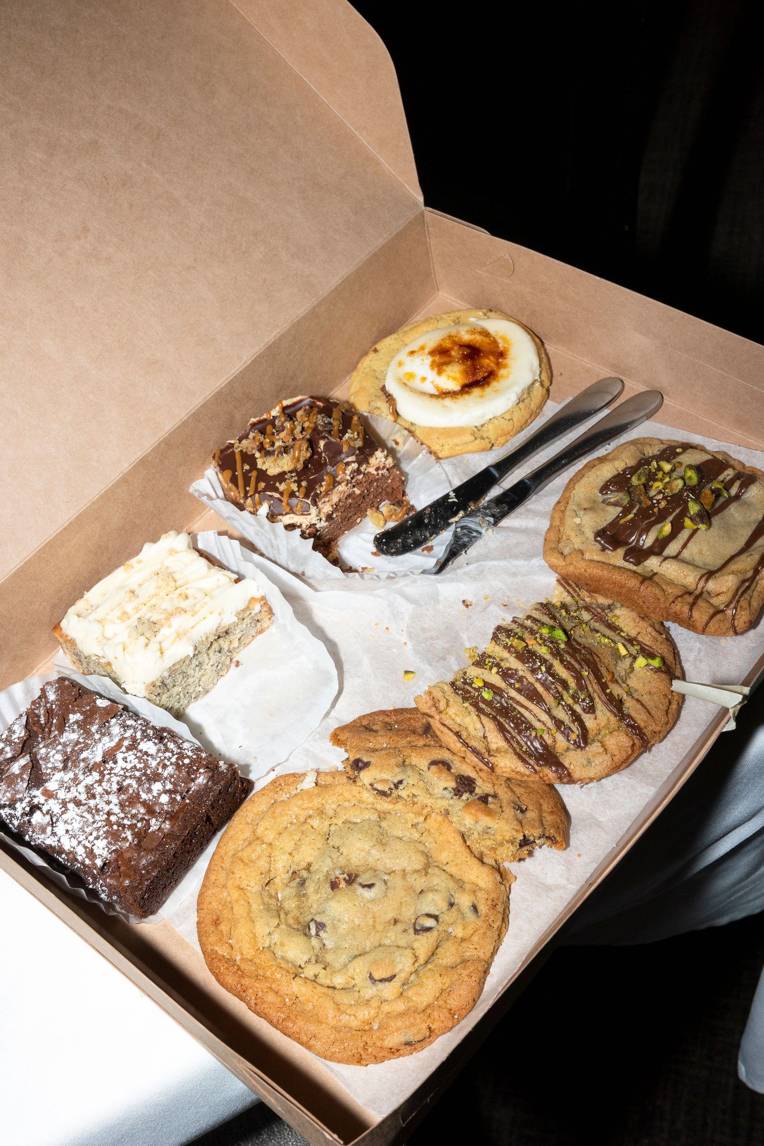 An assortment of cookies and desserts displayed in a cardboard box.
