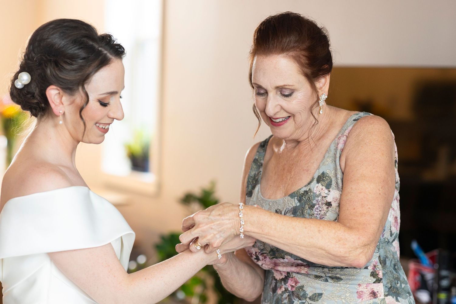 Final adjustments being made to wedding attire in a sunlit room.