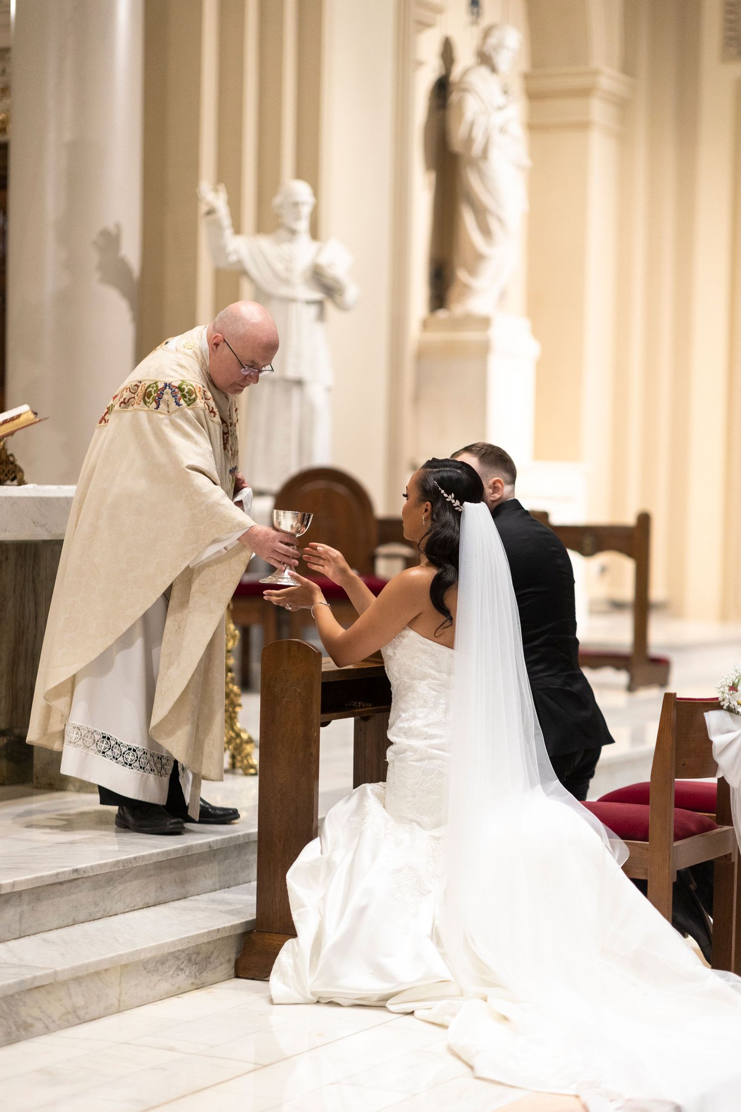 Wedding ceremony moments showing the couple receiving blessings at the church altar.