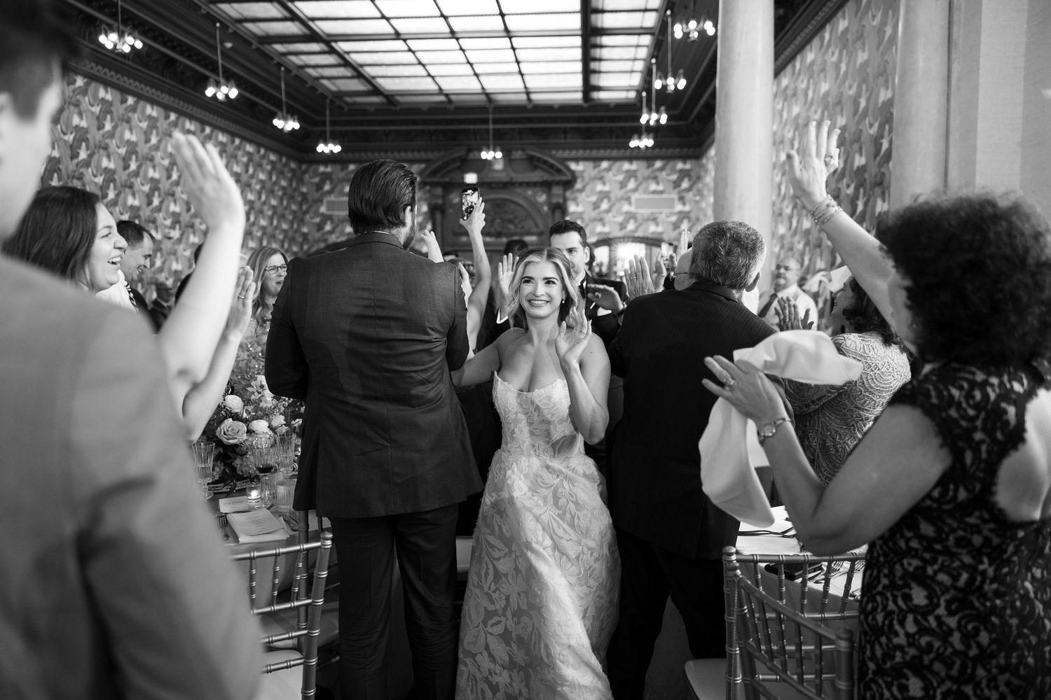 Wedding reception crowd standing and taking photos during celebration.