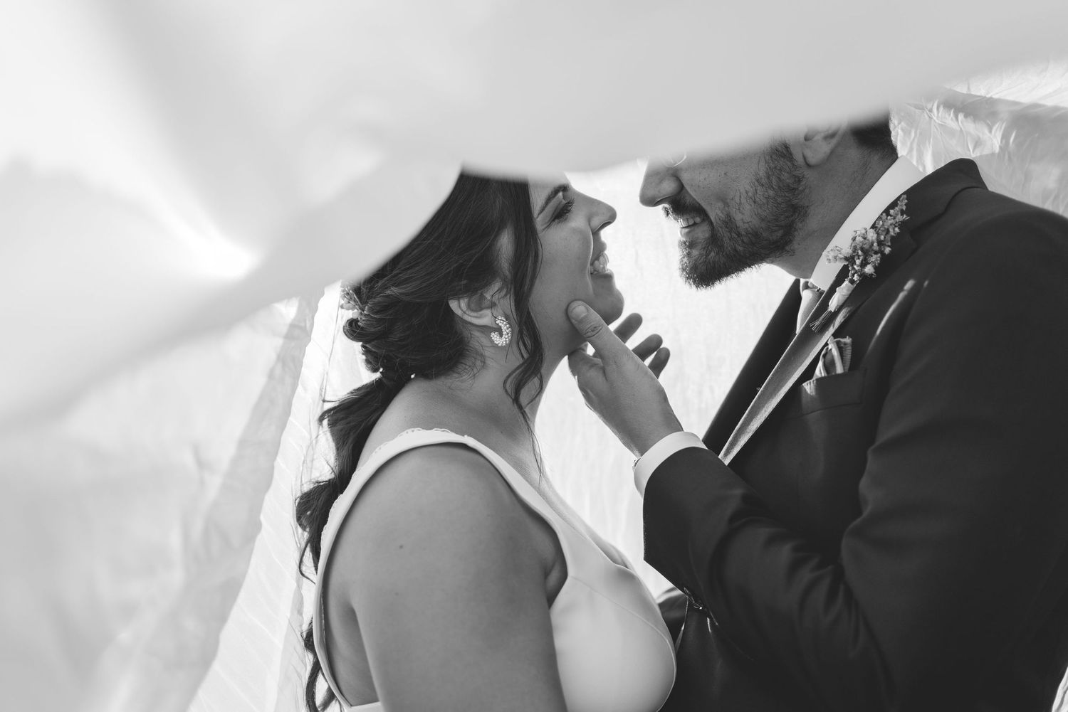 Intimate moment between bride and groom under the veil on their wedding day in Portugal