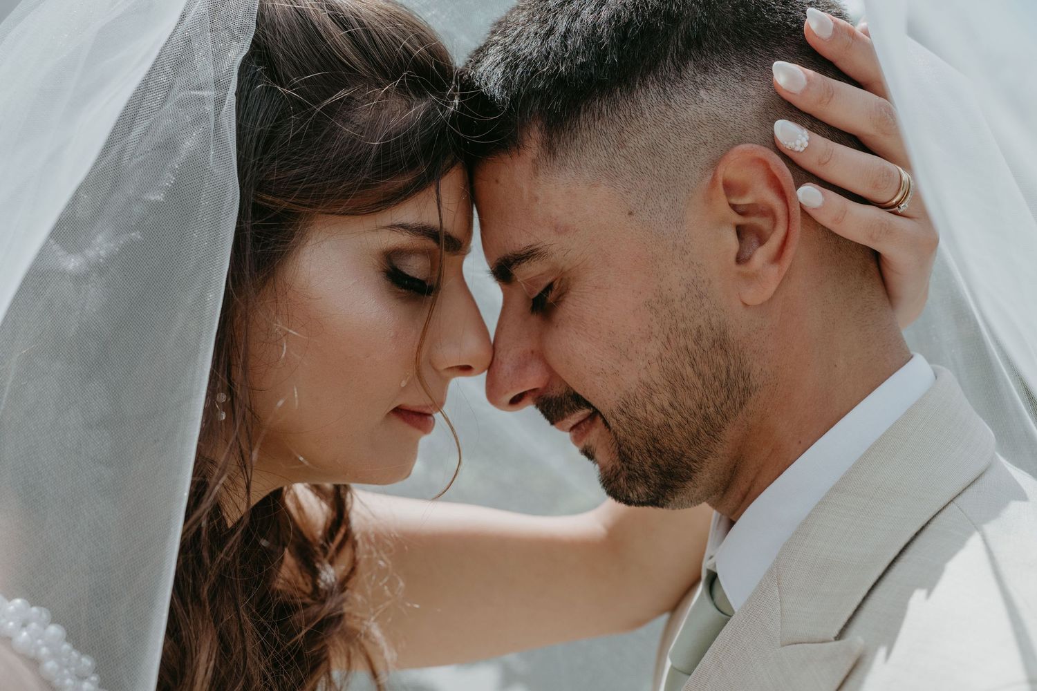 Intimate portrait of emotional bride and groom under the bridal veil in Portugal