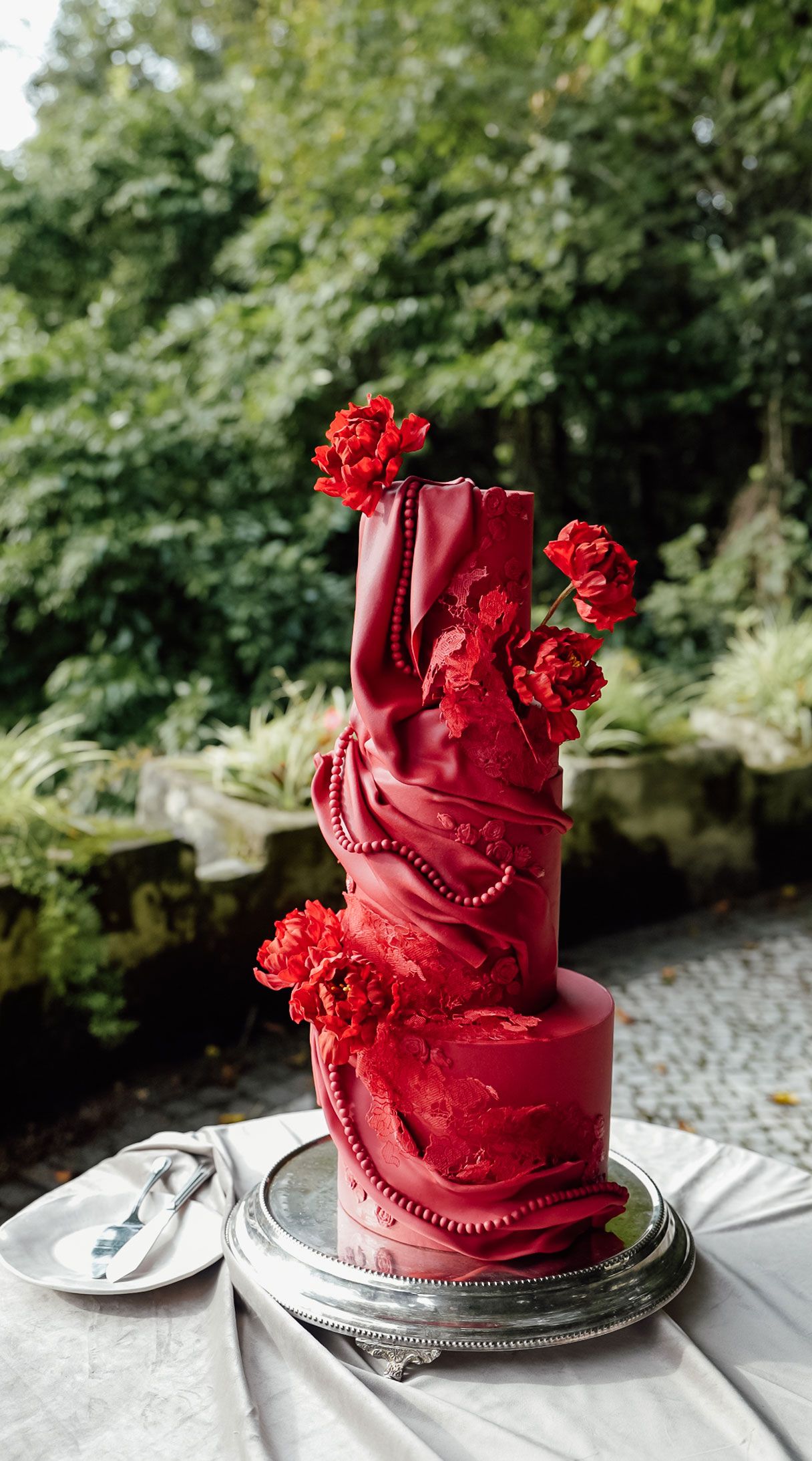Red floral wedding cake at Camélia Gardens in Sintra, Portugal