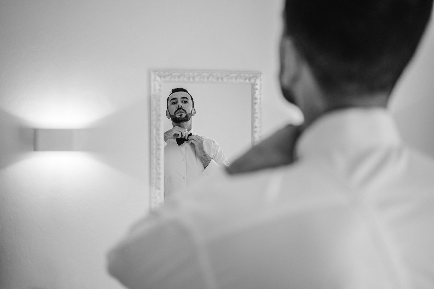 Artistic black and white photo of the groom getting ready on their wedding day in Portugal