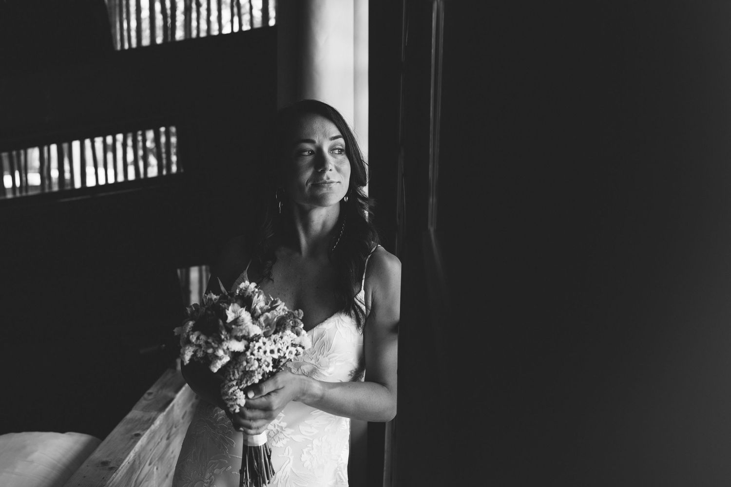 Black and white portrait of a bride holding her bouquet on her wedding day