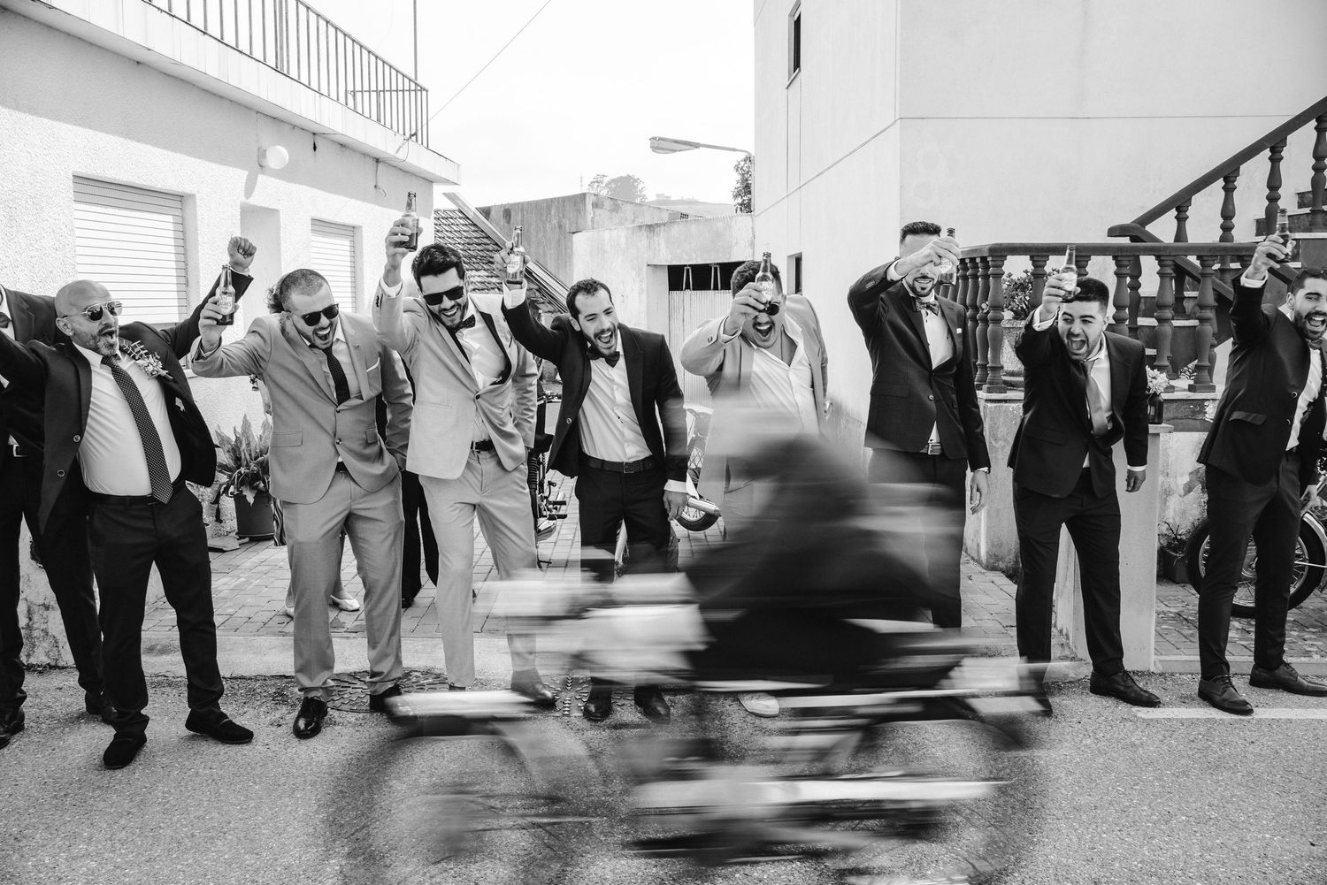 Black and white candid moment of wedding guests celebrating outdoors
