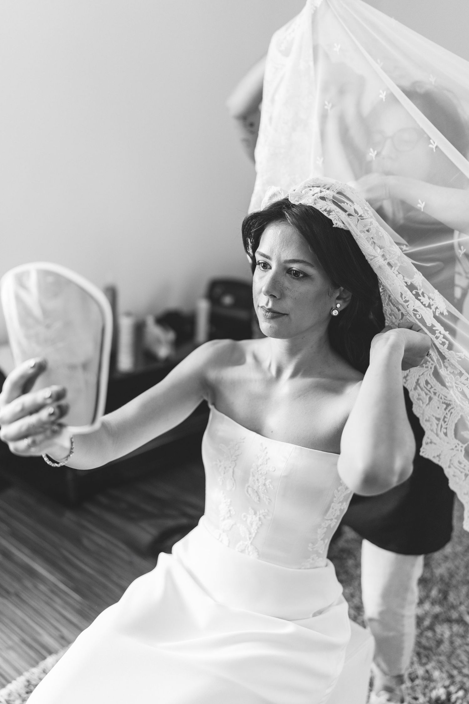 Black and white candid portrait of a bride getting ready on her wedding day