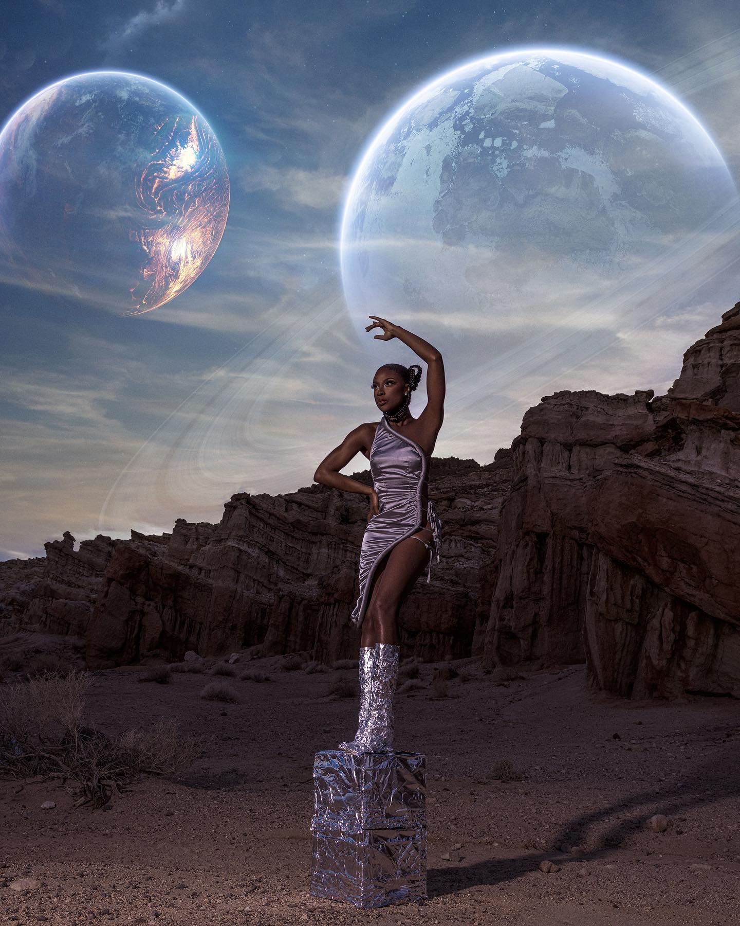 Dancer performs against desert rock formations with multiple planets visible in alien sky. PZ STUDIO VISUALS