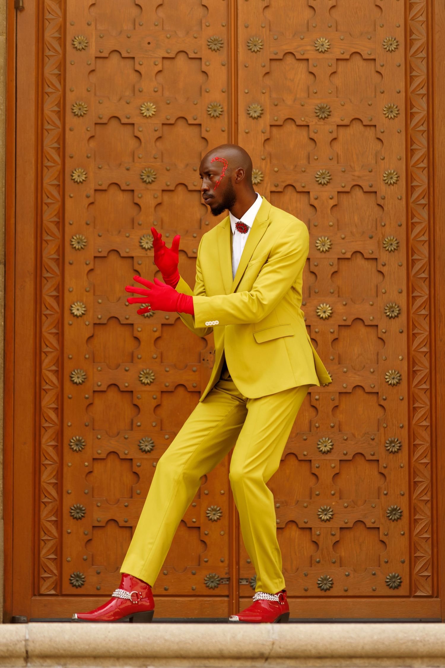 Stylized action poses in bright yellow suit against ornate wooden door. PZ STUDIO VISUALS  x Beoncia Dunn