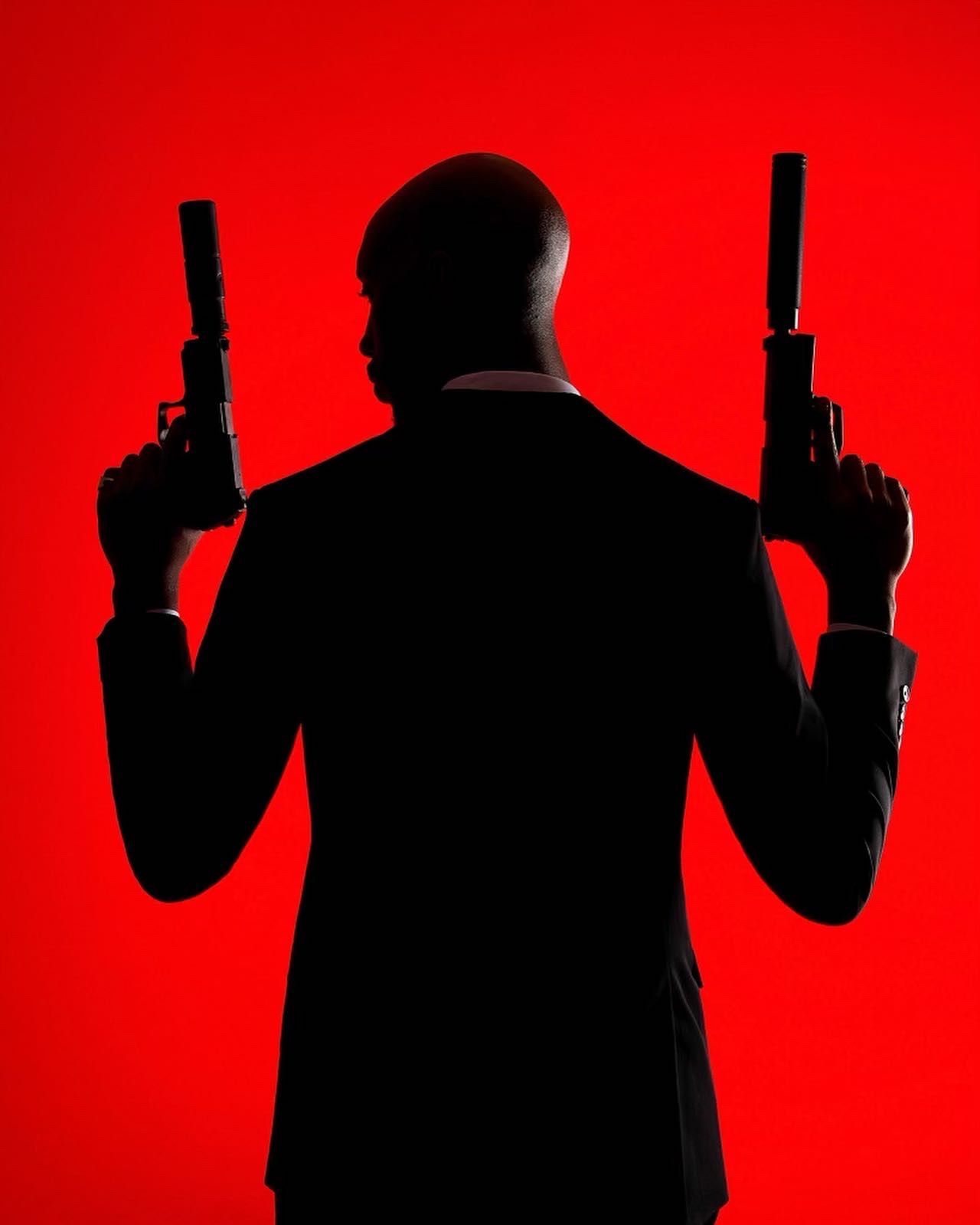Silhouetted figure holding guns against red background in dramatic pose. PZ STUDIO VISUALS Agent 47 now AGENT 26 - A NEW DAWN