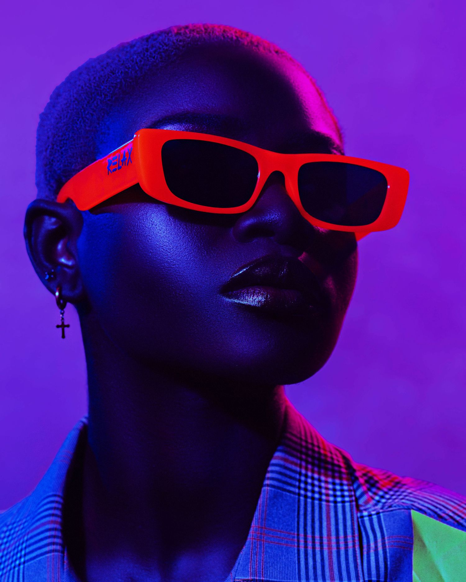 Artistic portrait series with neon lighting and red sunglasses against vibrant purple background. Modesta Boafo PZ STUDIO VISUALS