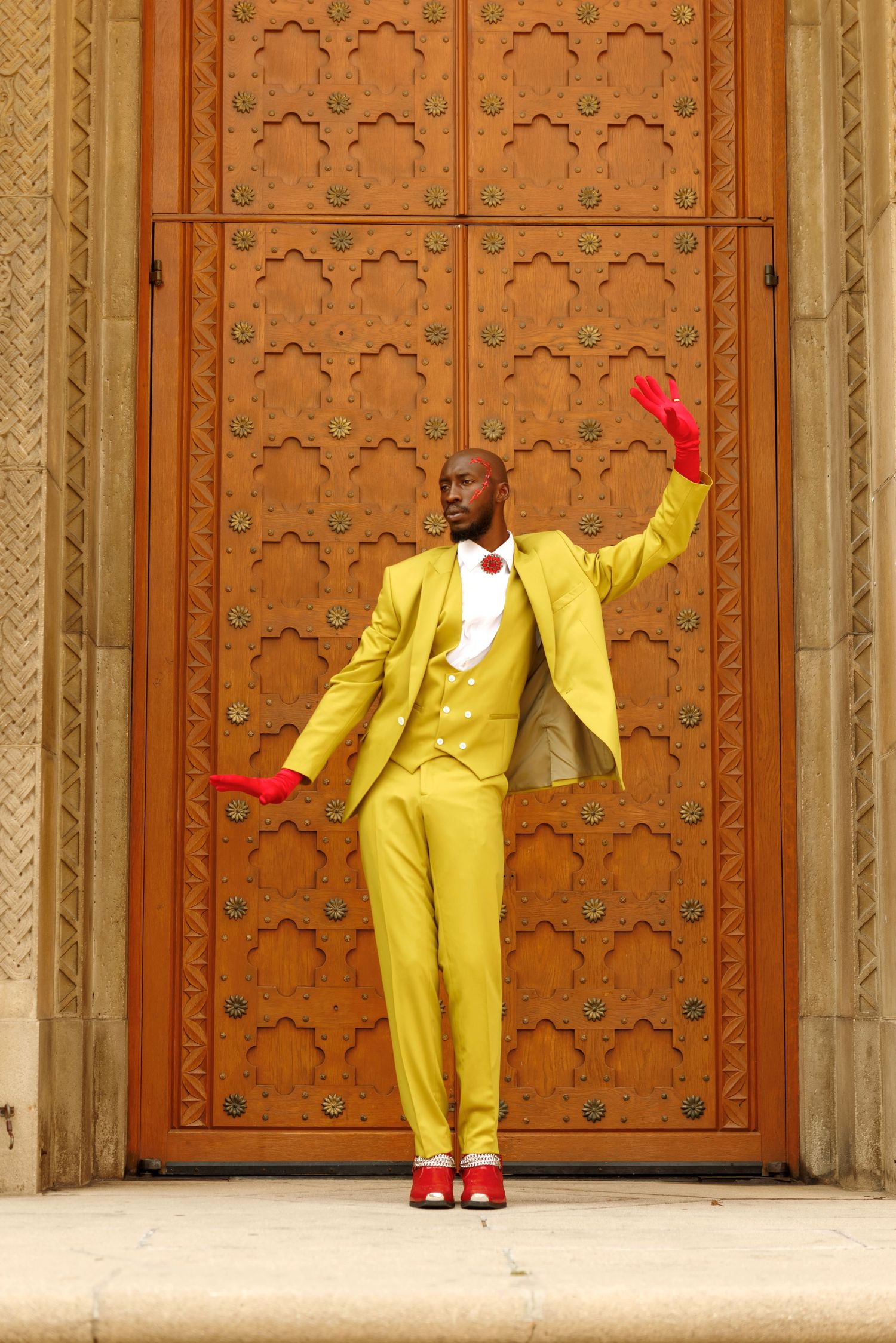 Yellow-suited figure strikes dynamic poses against decorative wooden door backdrop. PZ STUDIO VISUALS  x Beoncia Dunn