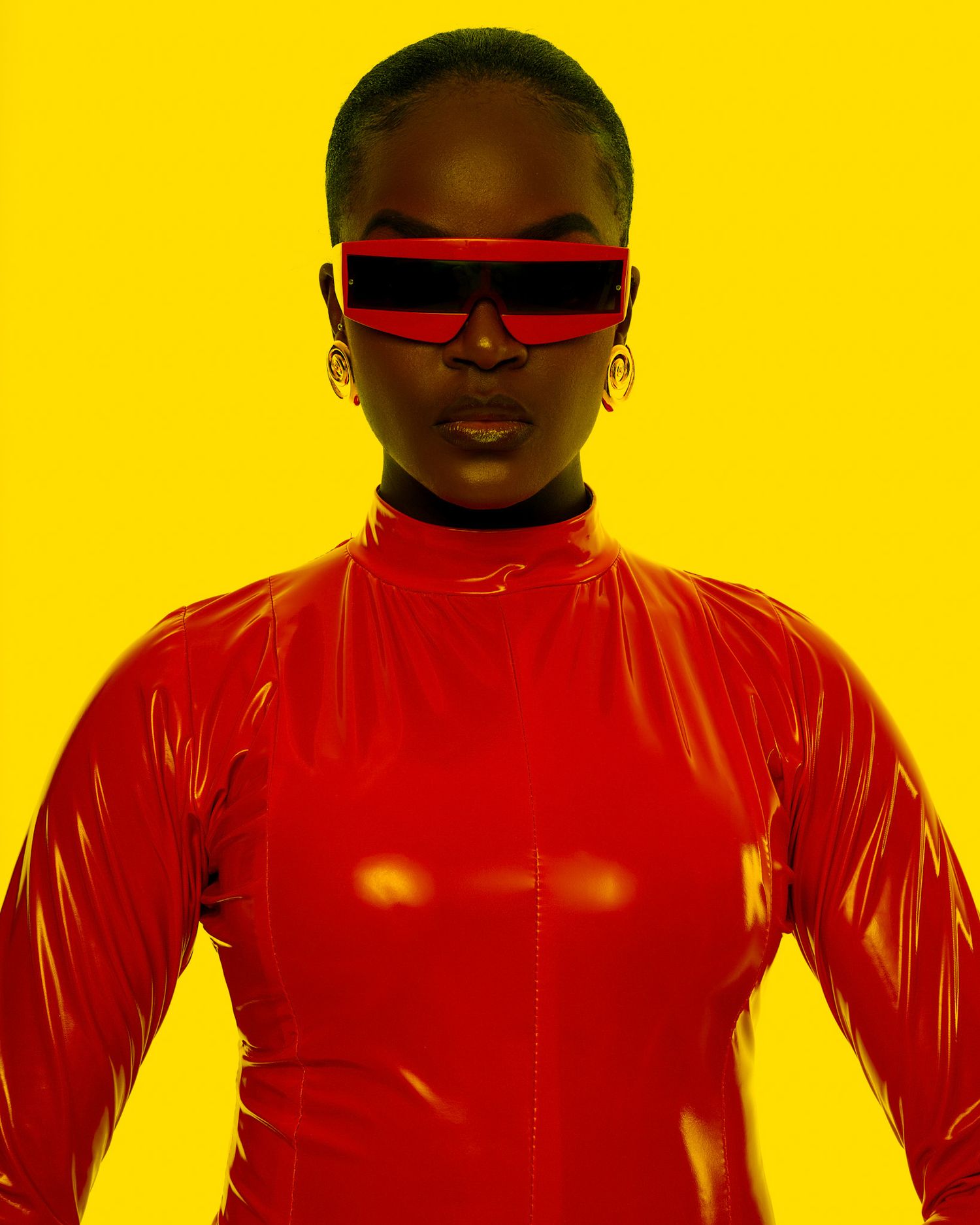 Bold fashion portrait with red latex outfit against bright yellow background. PZ STUDIO VISUALS