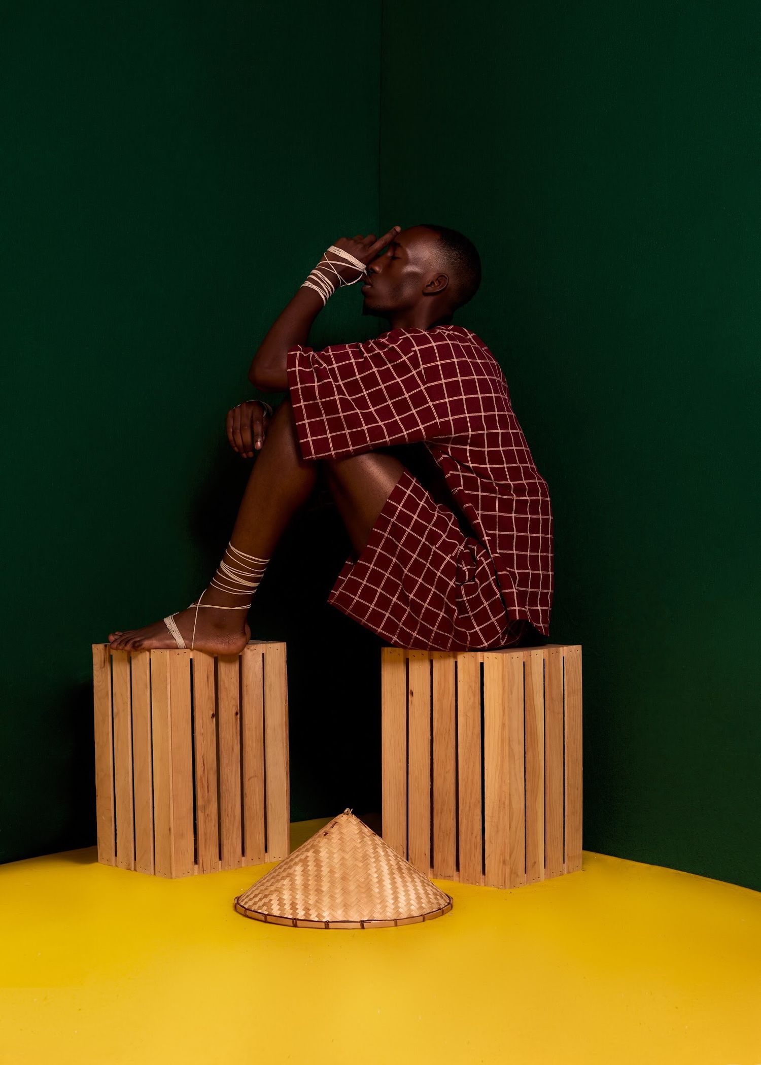 Artistic composition with wooden crates on yellow surface against dark green wall.PZ STUDIO VISUALS