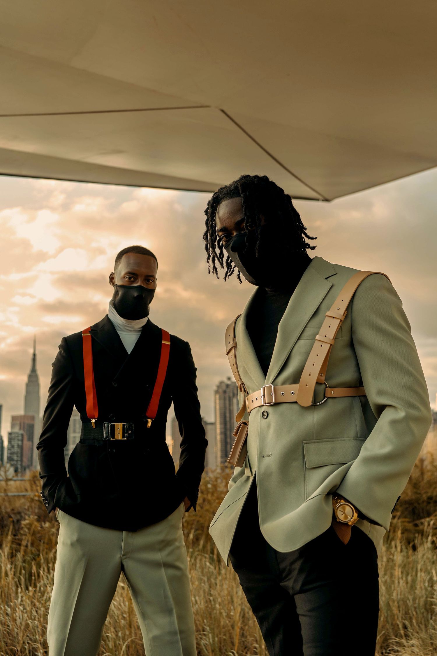 Fashion editorial with models in light suits and orange harnesses against urban sunset backdrop. PZ STUDIO VISUALS